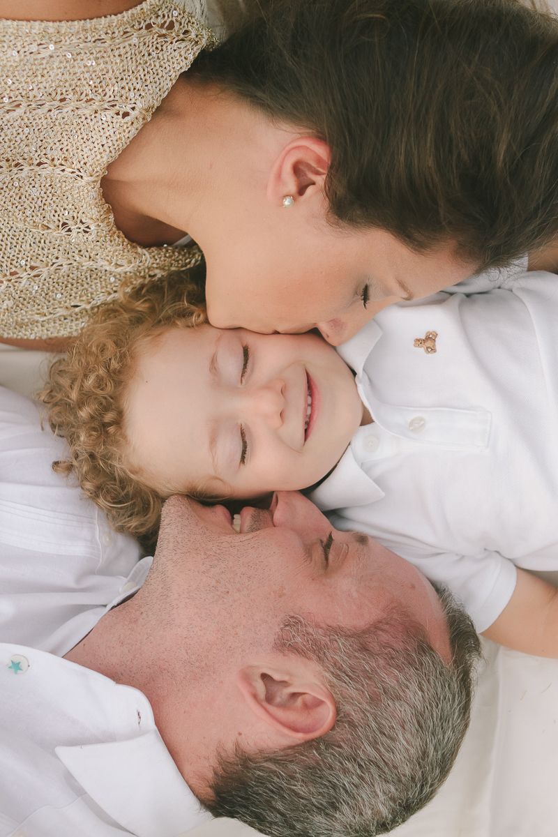 Couple giving sweet kiss to their son, close-up NYC family photography by Paula Brearley NYC family photographer