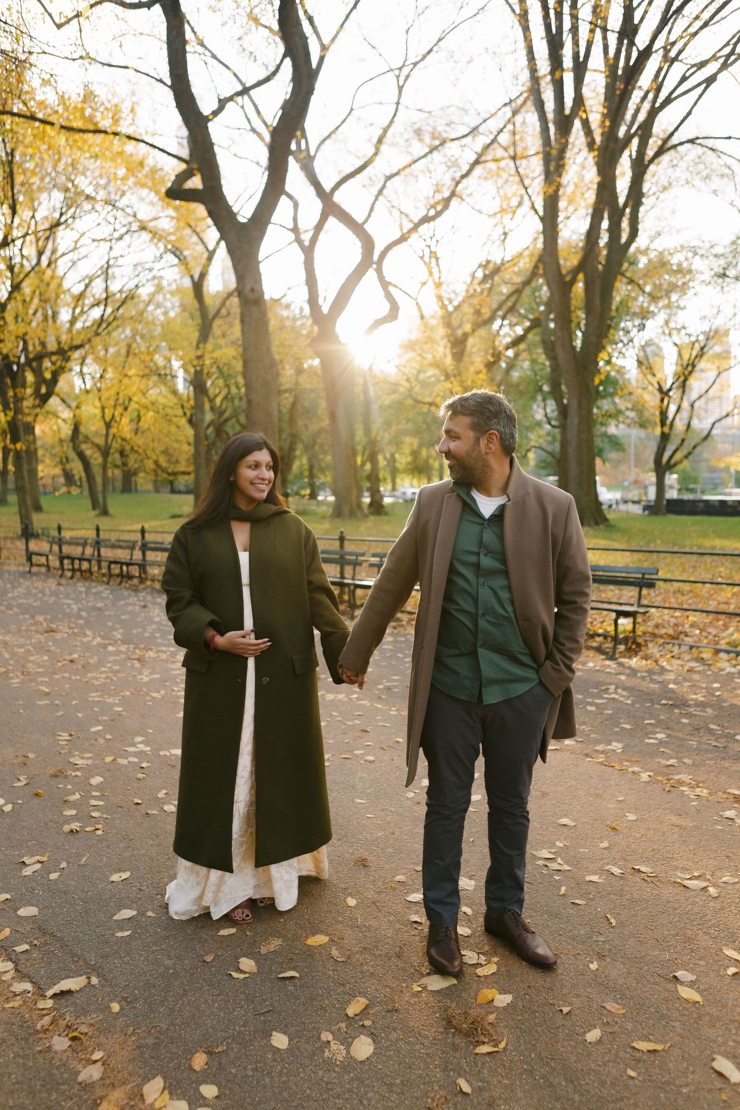 Couple holding hands during golden hour maternity session at Central Park, NYC, Paula Brearley NYC maternity photographer