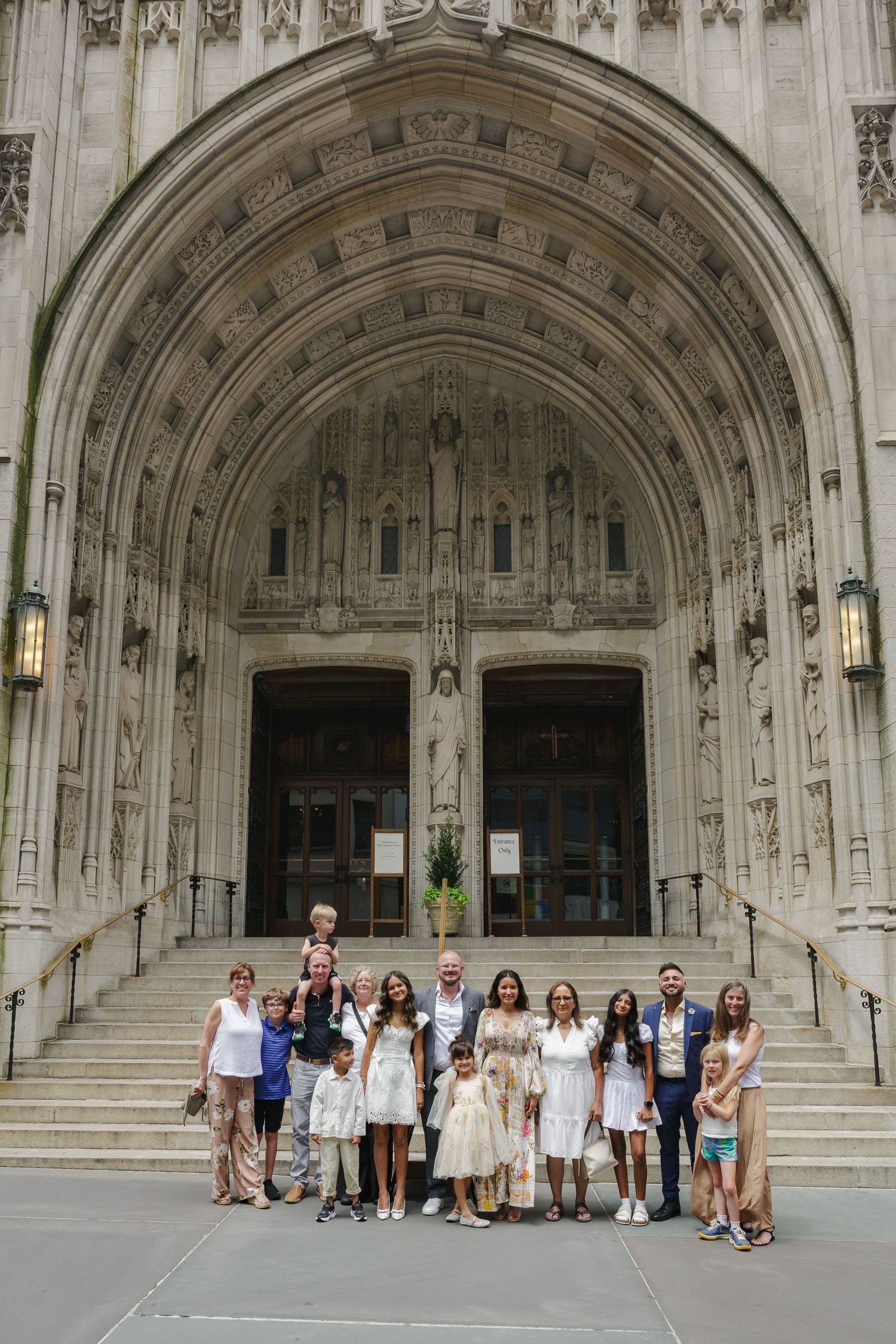 Grand family portrait with St. Thomas Church Fifth Avenue NYC background by Paula Brearley NYC baptism photographer