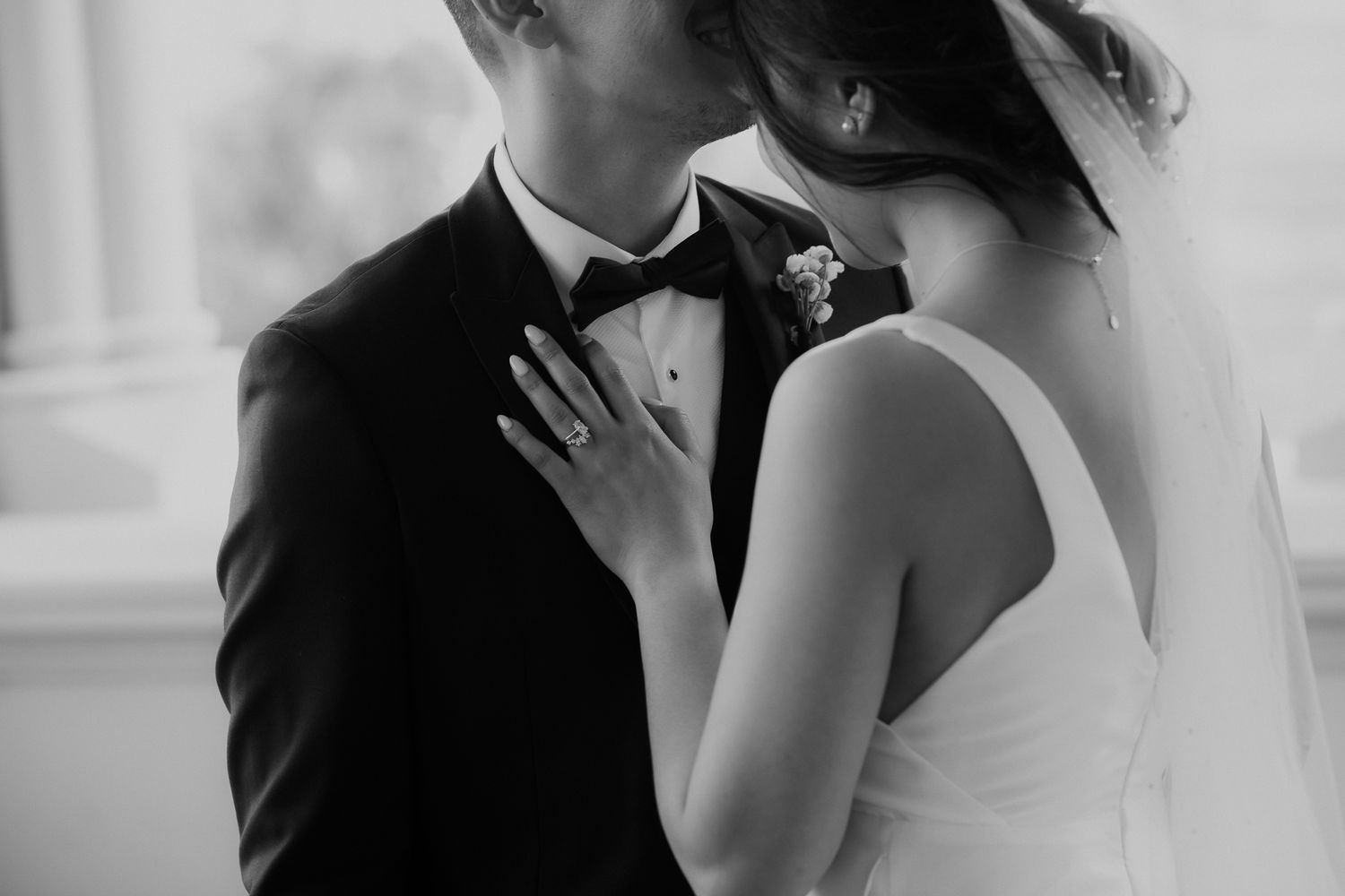 Black and white close up of elegant bride with her hand on her grooms chest at their Wellington Wedding by August and Vi