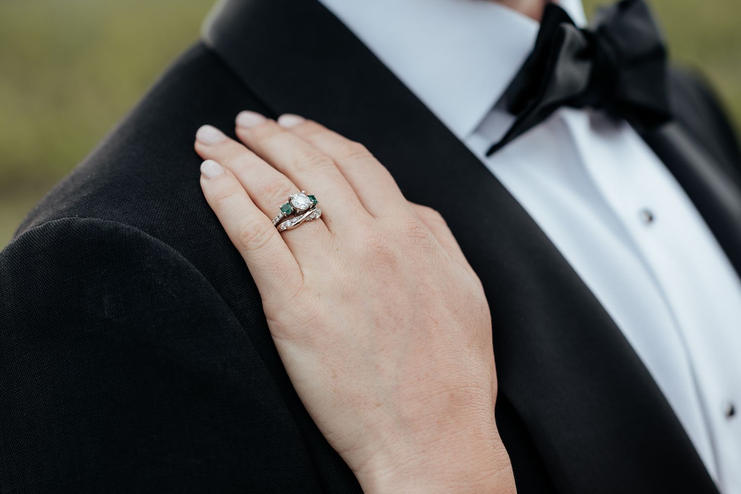 Close-up view of hand wearing wedding ring during an elegant black tie ceremony by August and Vine