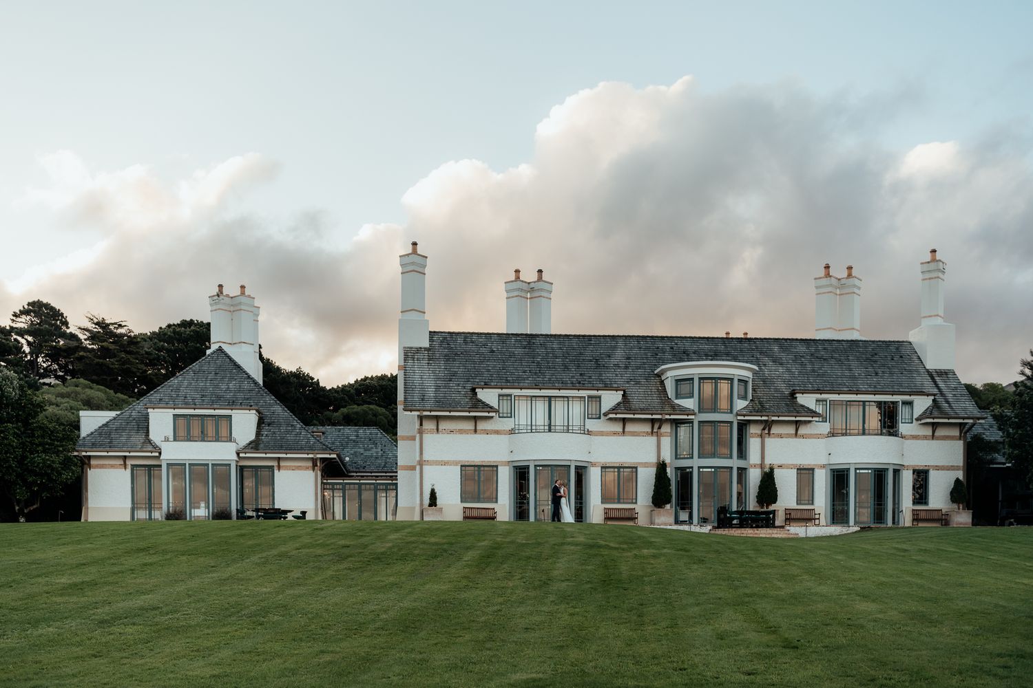 Elegant and grand Wharekauhau Lodge Wairarapa with gabled roofs and large windows on an expansive lawn by August and Vine