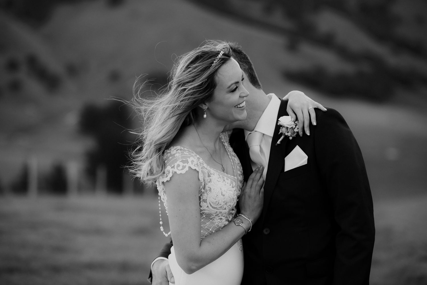 Black and white wedding photo of a romantic moment in the wind between a couple on their special day by August and Vine