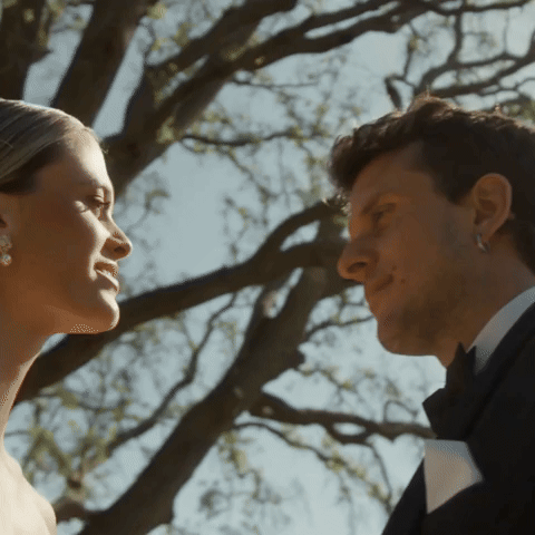 Couple kiss on their wedding day under trees by August and Vine