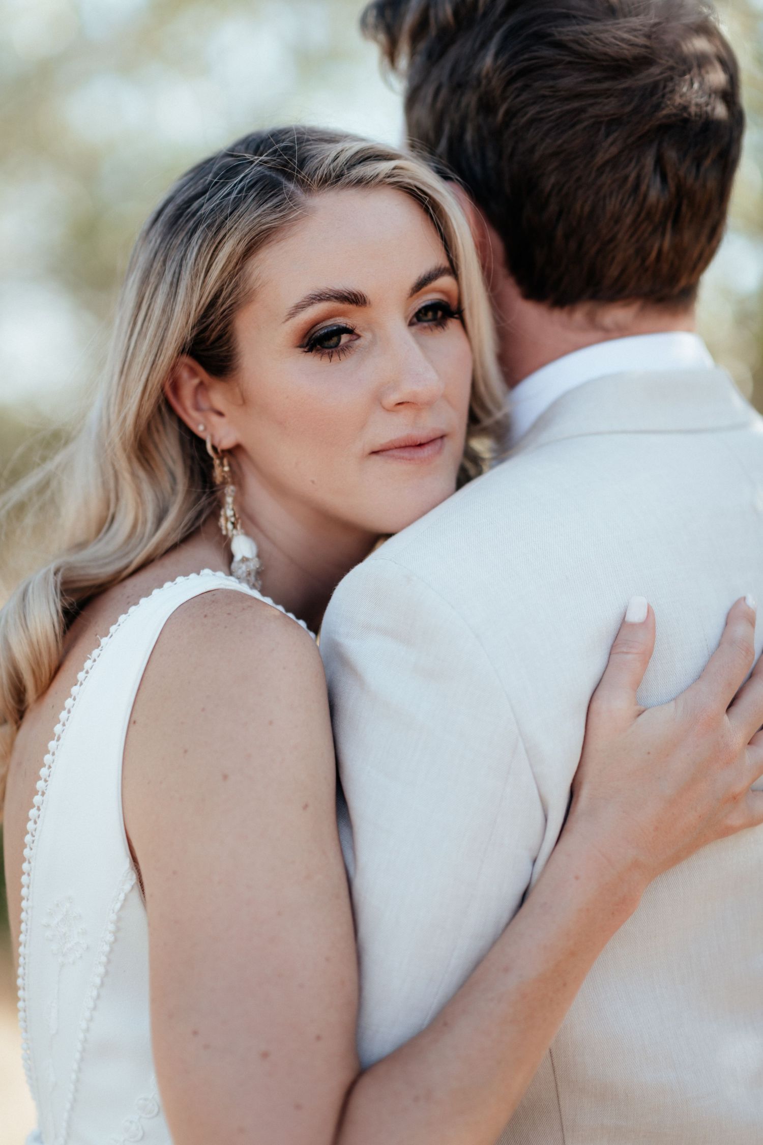 A close up sequence of a bride and groom embracing during their romantic outdoor wedding photoshoot by August and Vine