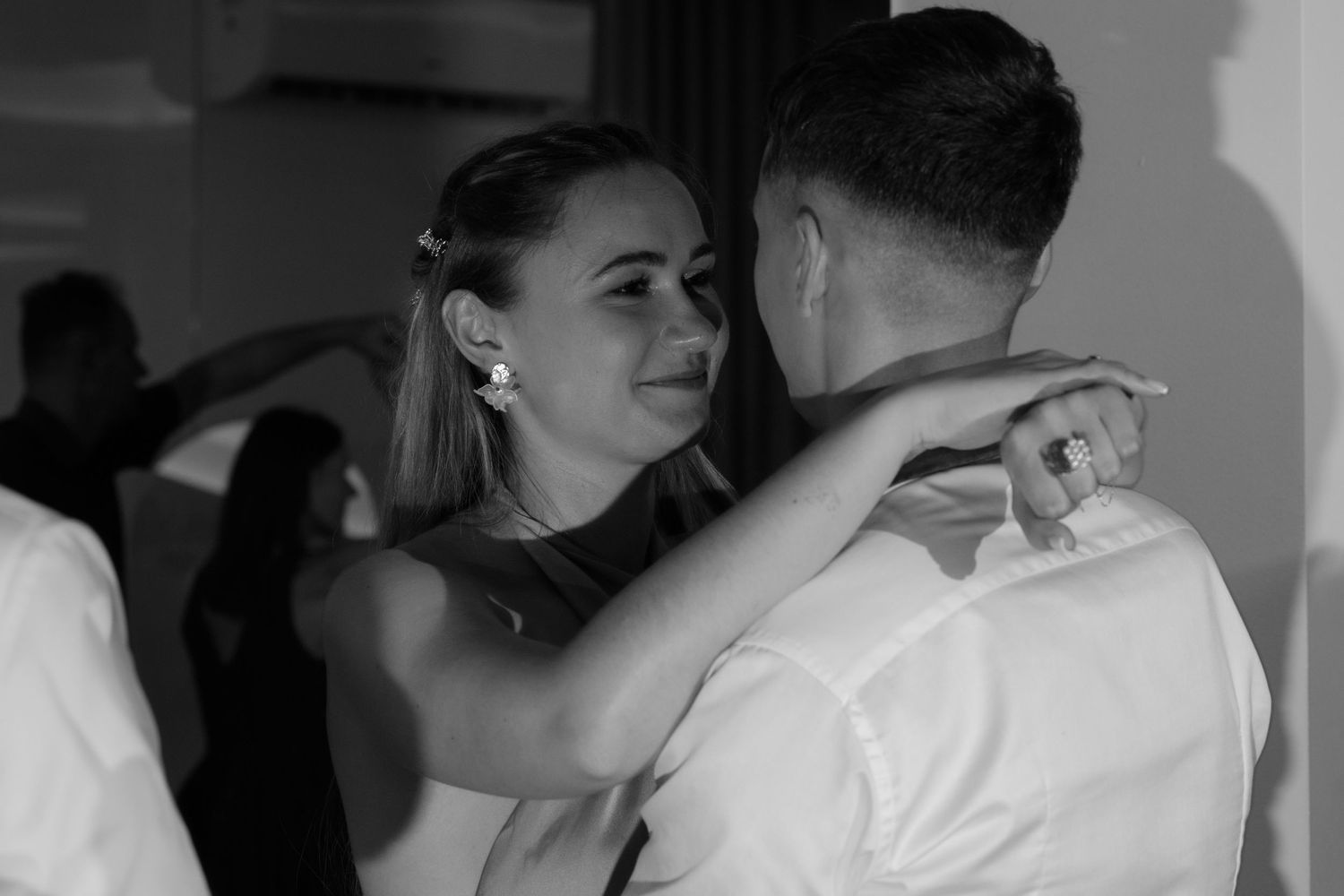 A black and white photograph showing a couple sharing an intimate dance together at a special event.