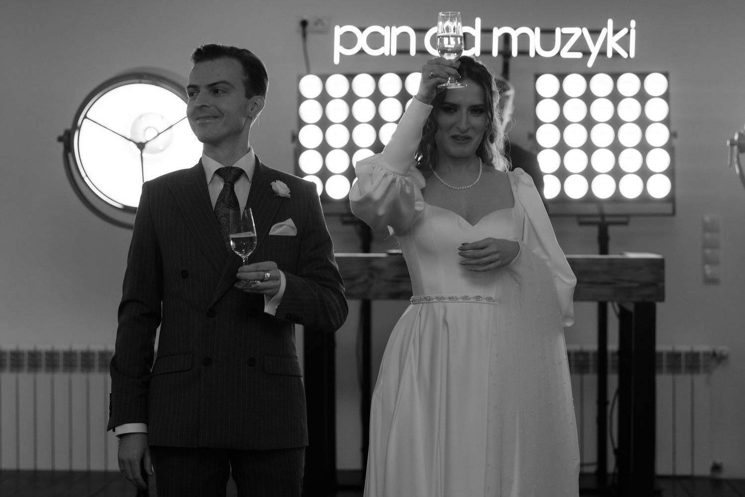 A black and white photograph of a newlywed couple standing together at their wedding ceremony.