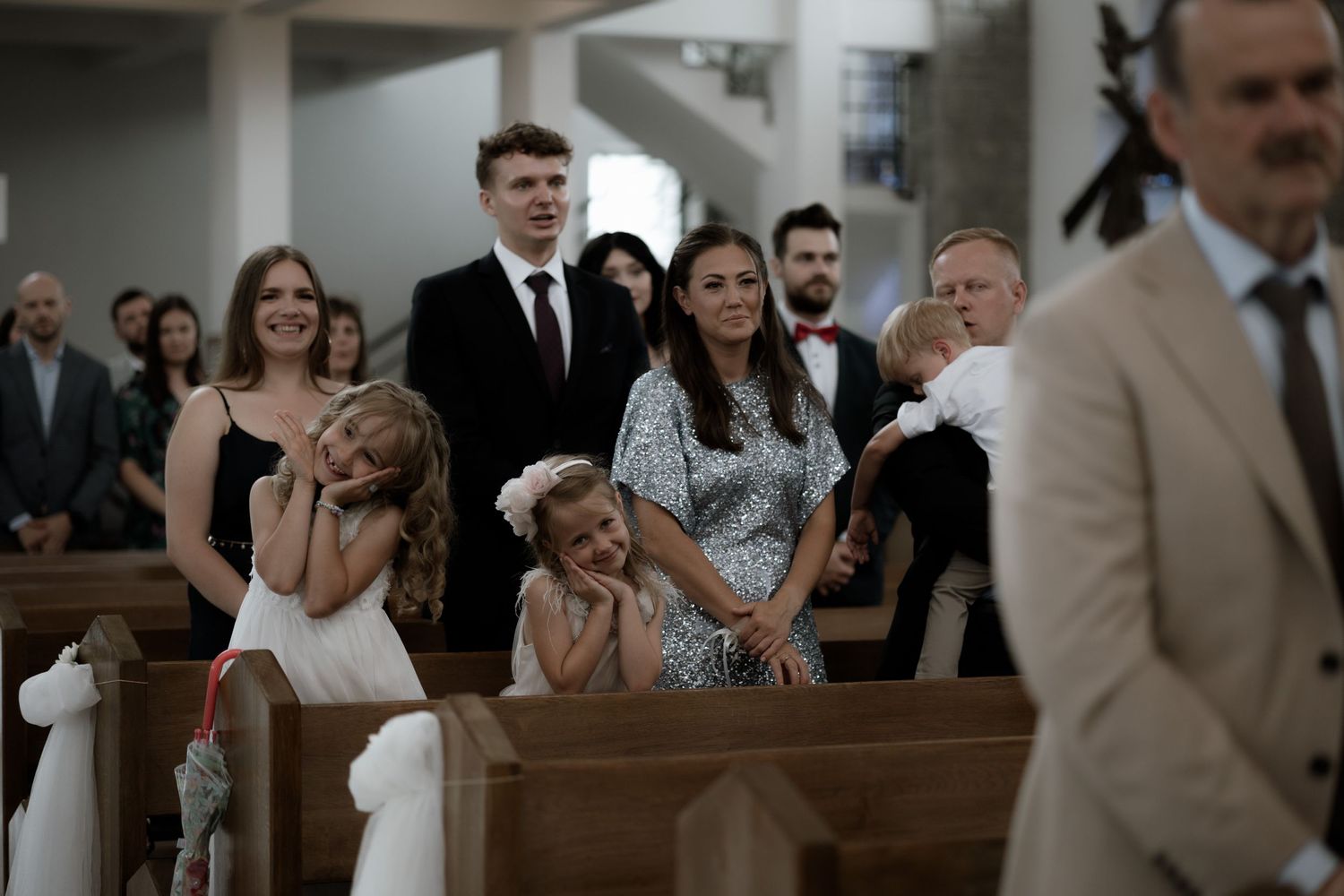 Emotional wedding guests react with joy and laughter during a church ceremony.