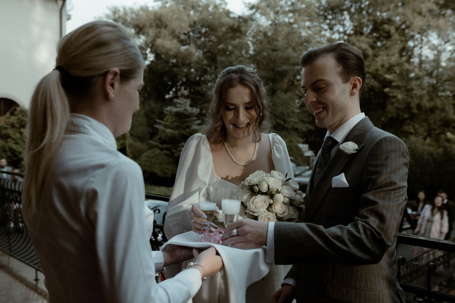 A wedding ceremony takes place outdoors as the couple participates in the ceremony with their officiant.