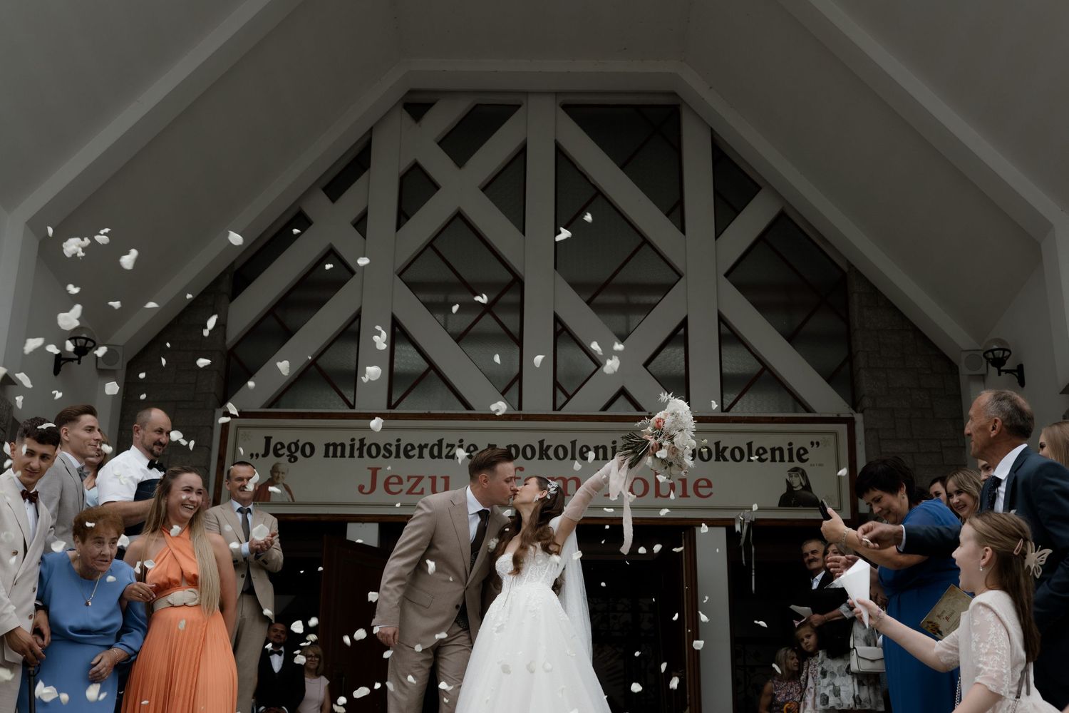 Wedding ceremony exit with guests blowing bubbles as couple walks through church doorway.