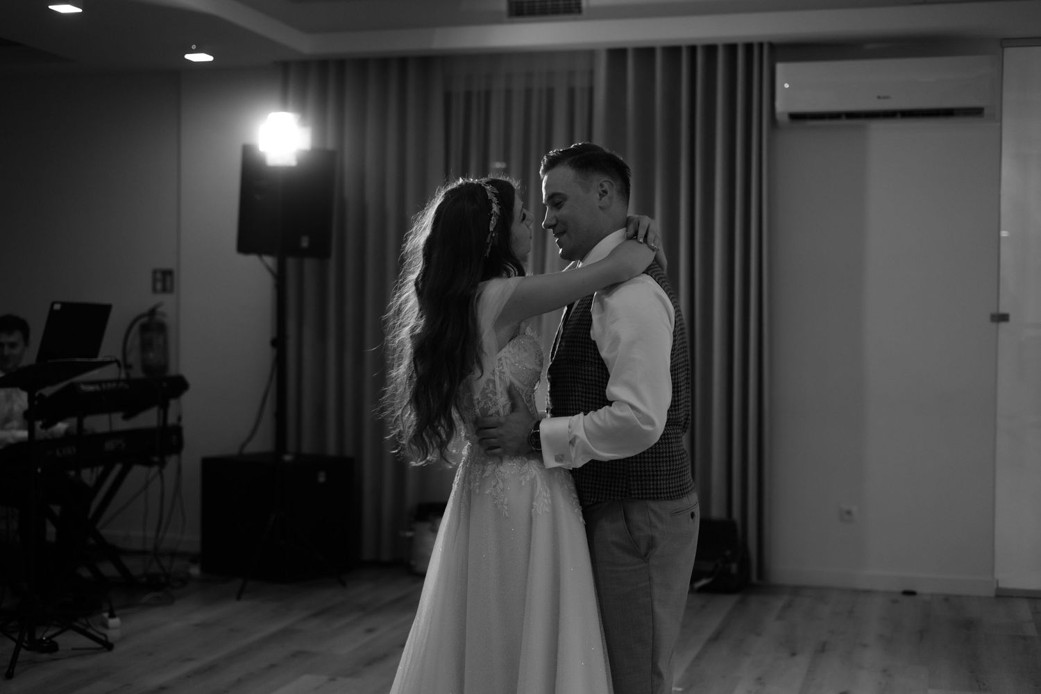 A romantic black and white photo of a couple sharing their first dance at a wedding reception.