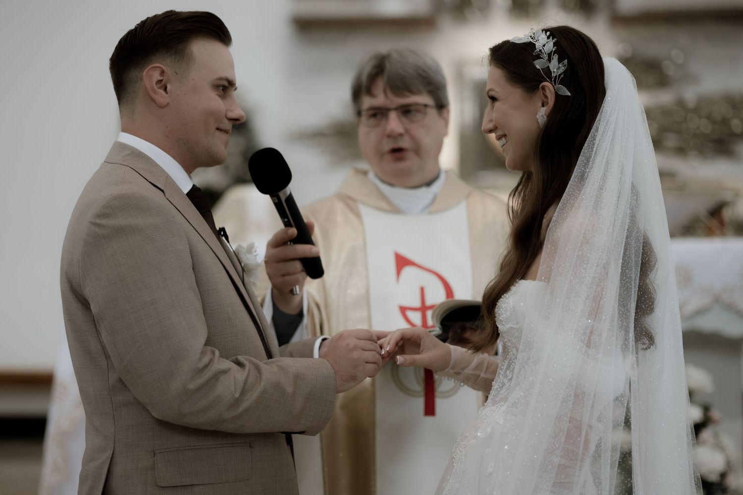 A wedding ceremony takes place inside a church with traditional decor and religious symbols.