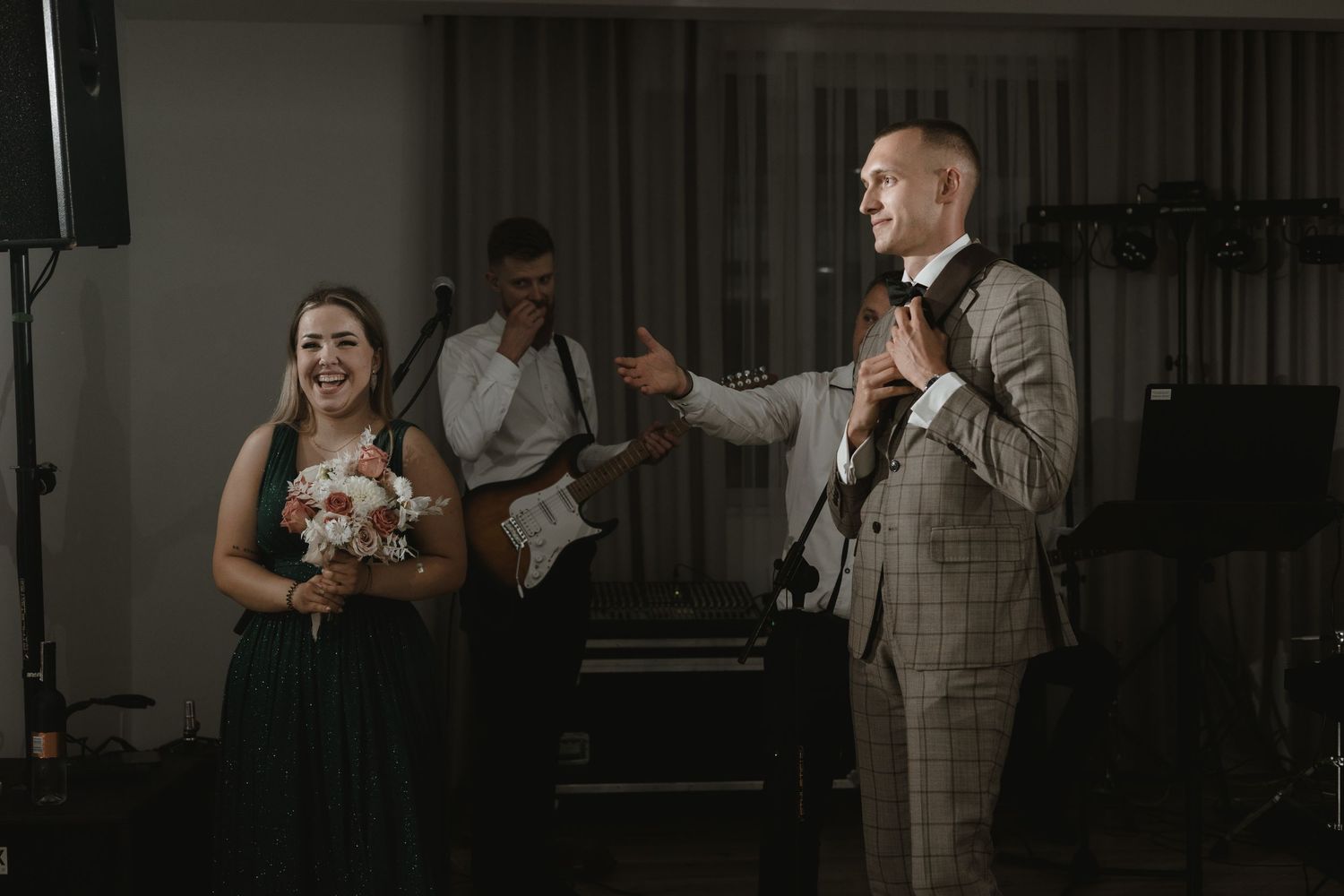 A joyful moment between newlyweds during their first dance at an indoor wedding reception.