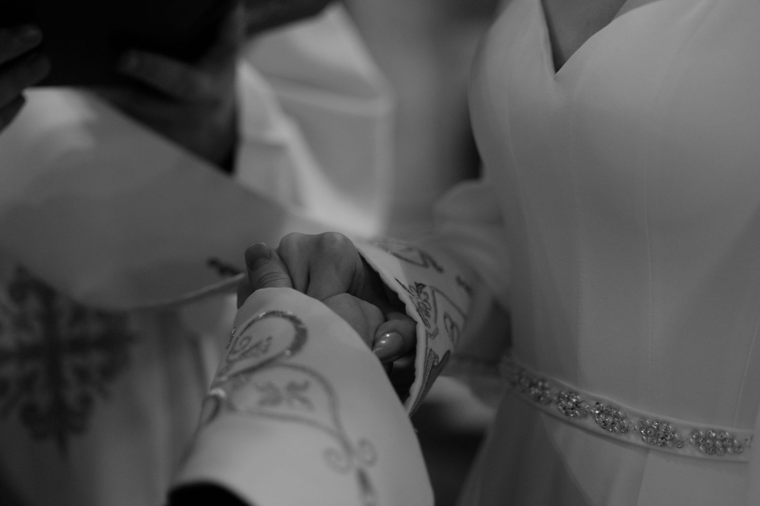 Black and white close-up image showing a detailed lace pattern on fabric.