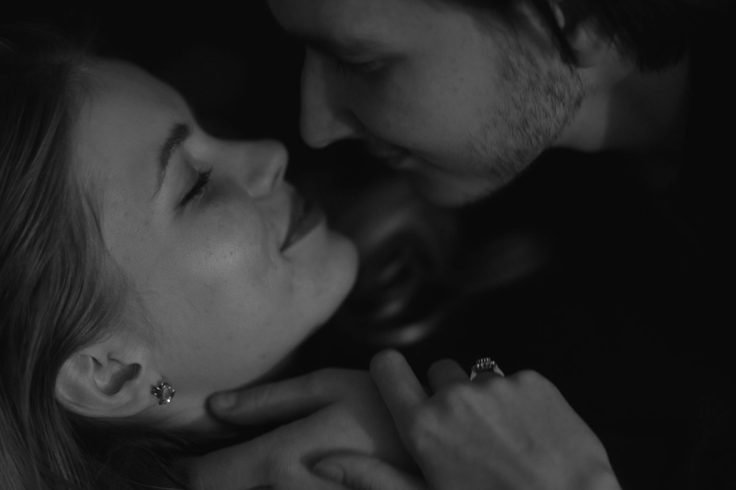 A tender romantic moment captured in black and white as two people share an intimate close embrace.