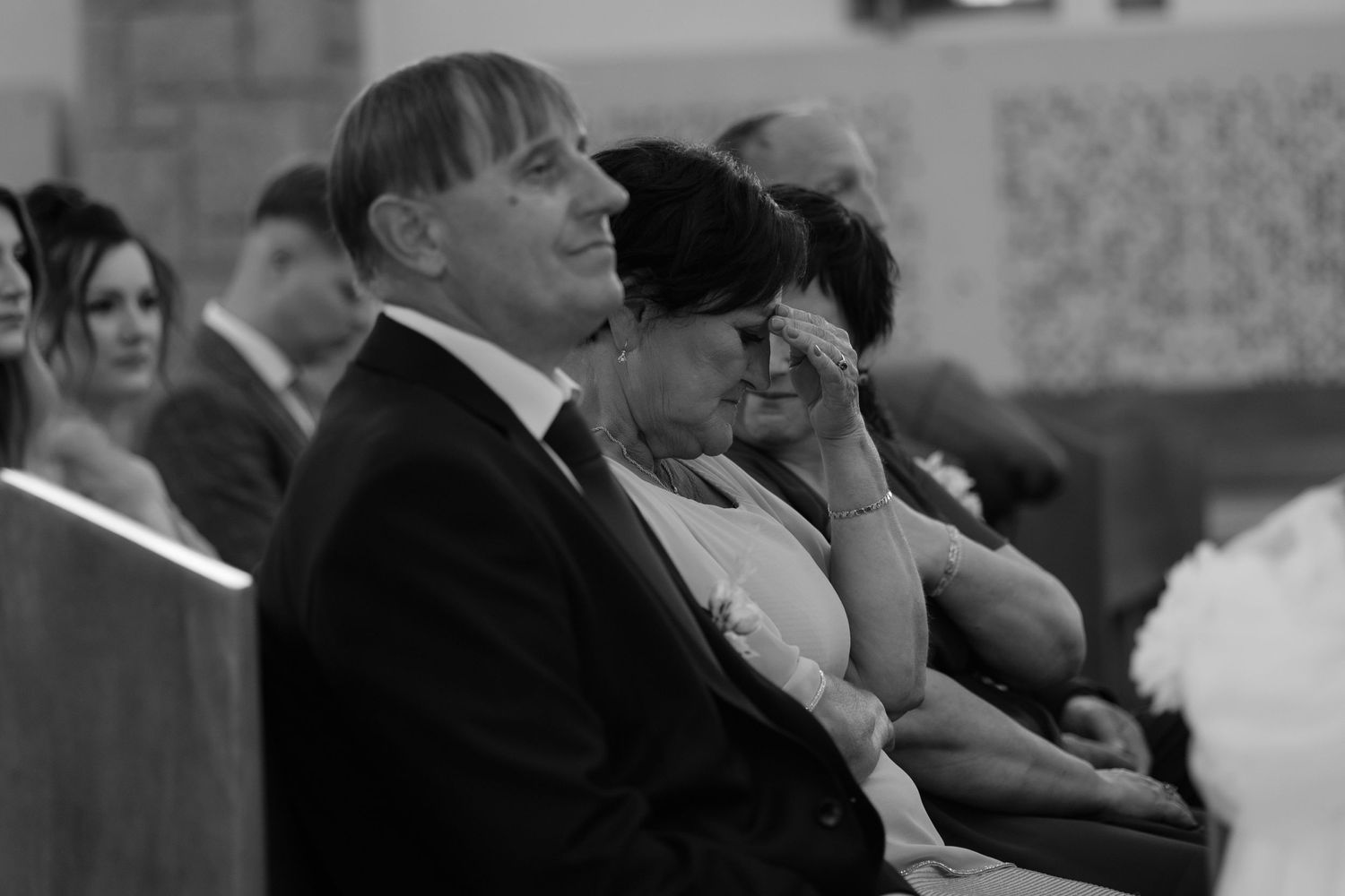 Black and white photo showing people sitting in a row at what appears to be a formal event or ceremony.