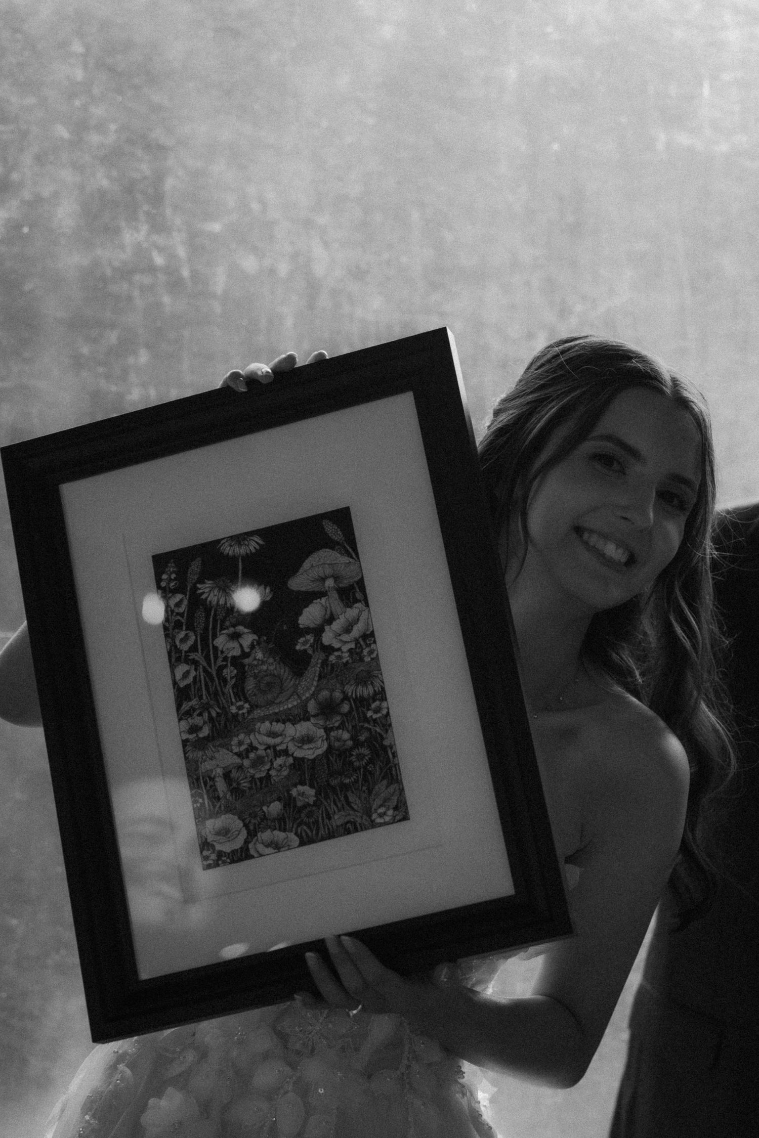 A series of black and white photographs arranged in a horizontal sequence showing framed artwork displays.