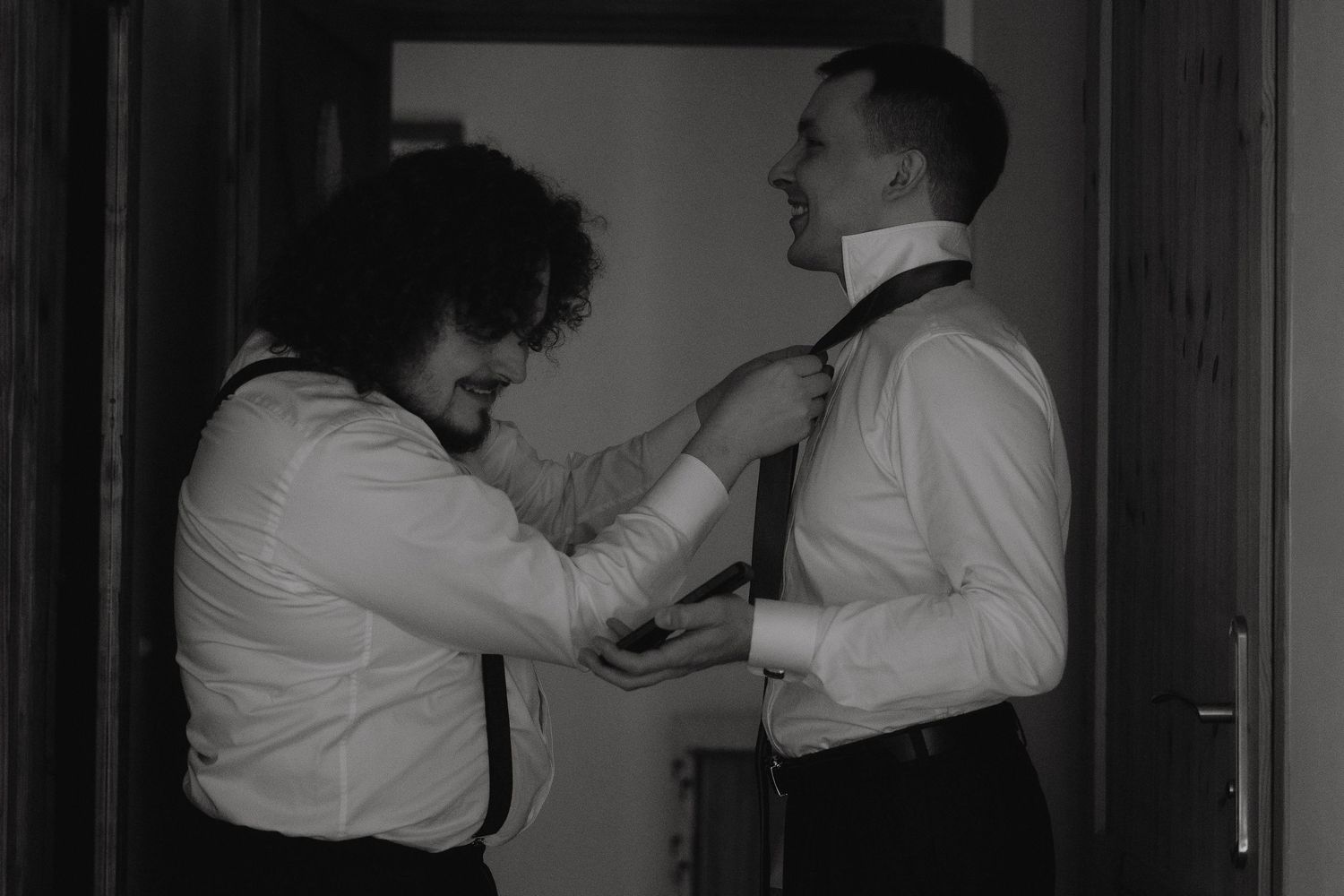 A black and white photograph shows two people dancing in formal attire during what appears to be a ballroom dance.