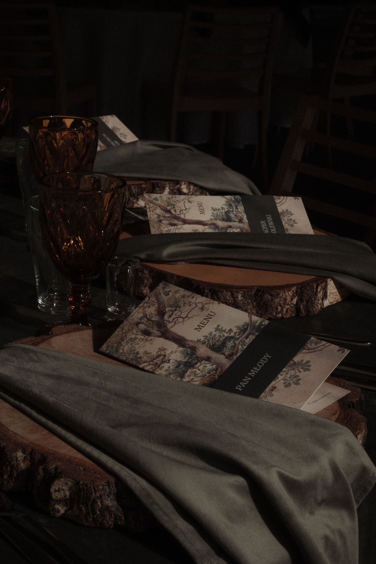 A series of dark moody photos showing books and papers arranged in a vintage style setting with dramatic lighting.