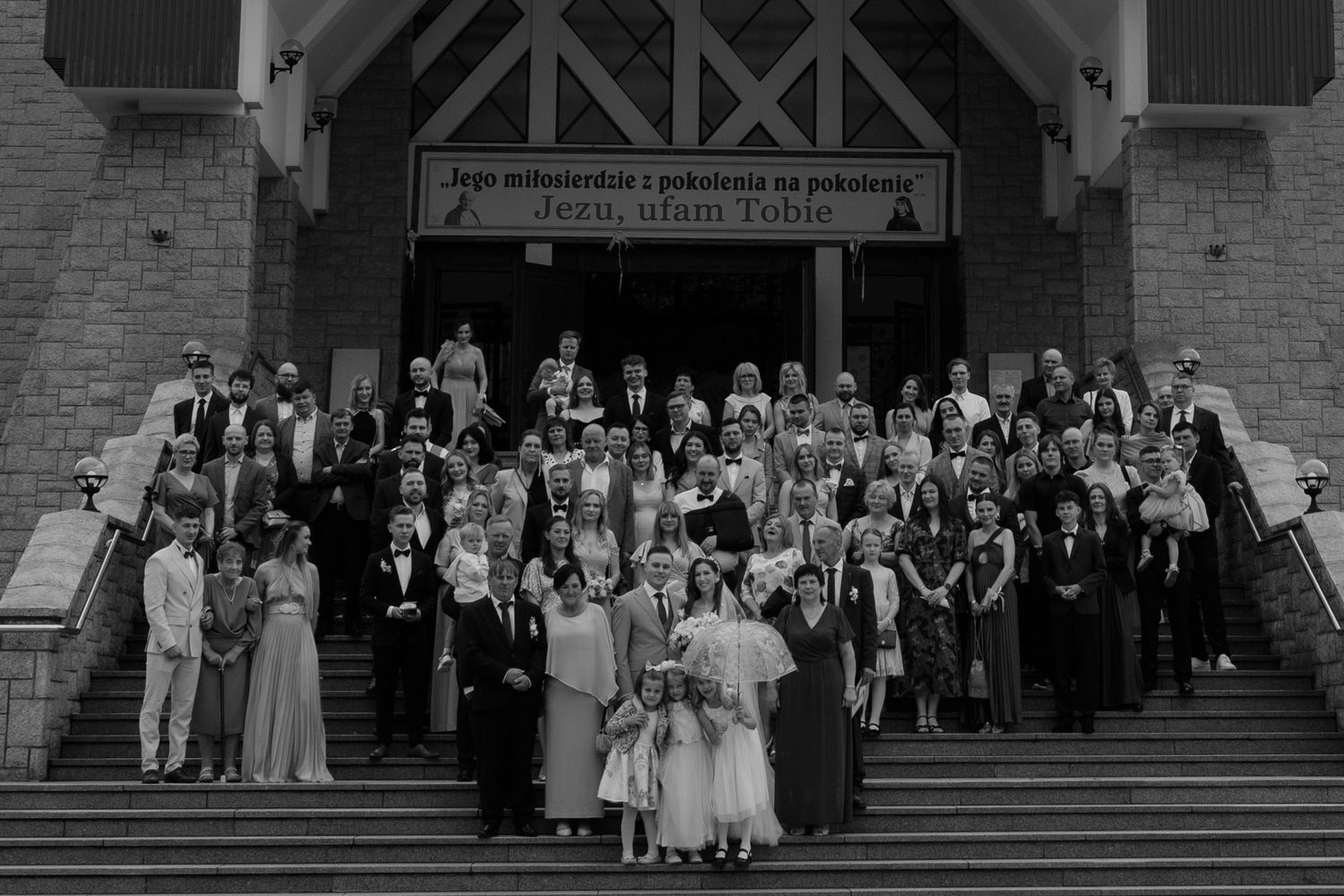 Black and white vintage photograph of large group standing on church steps for formal gathering.