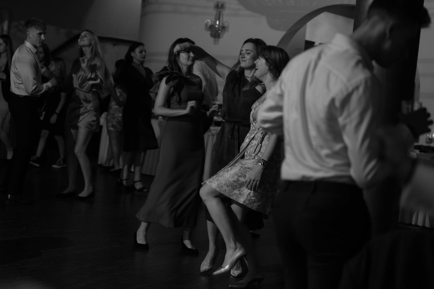 People dancing together at a vintage-style social gathering in black and white.