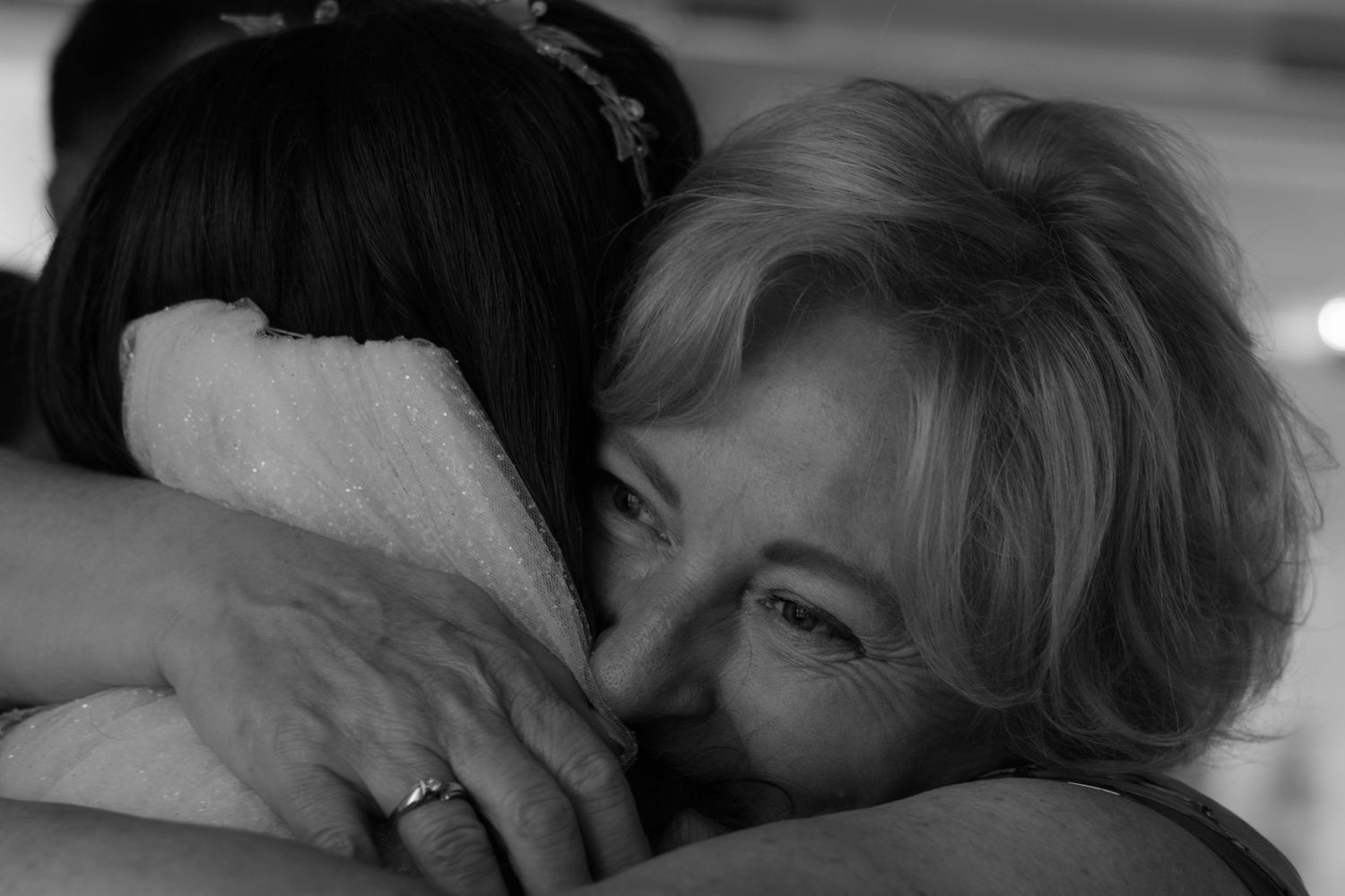 A tender black and white photograph capturing an emotional embrace during a special celebration.