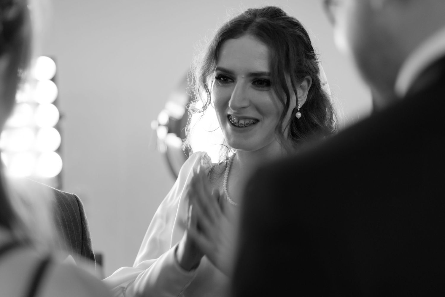 A joyful moment captured in black and white as someone smiles and claps during a celebration.