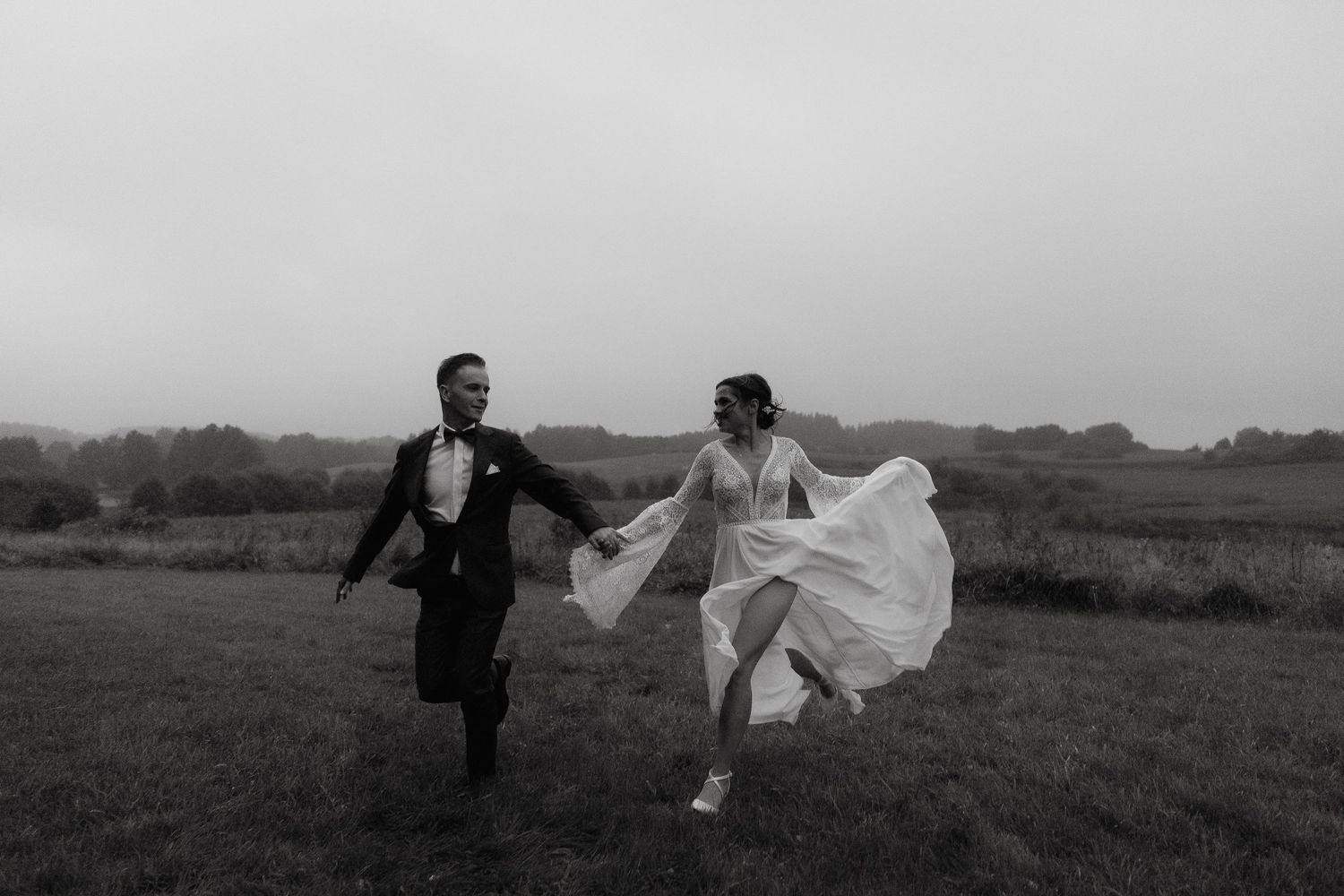 A sequence of black and white photos showing a couple running and playing together in an open field.