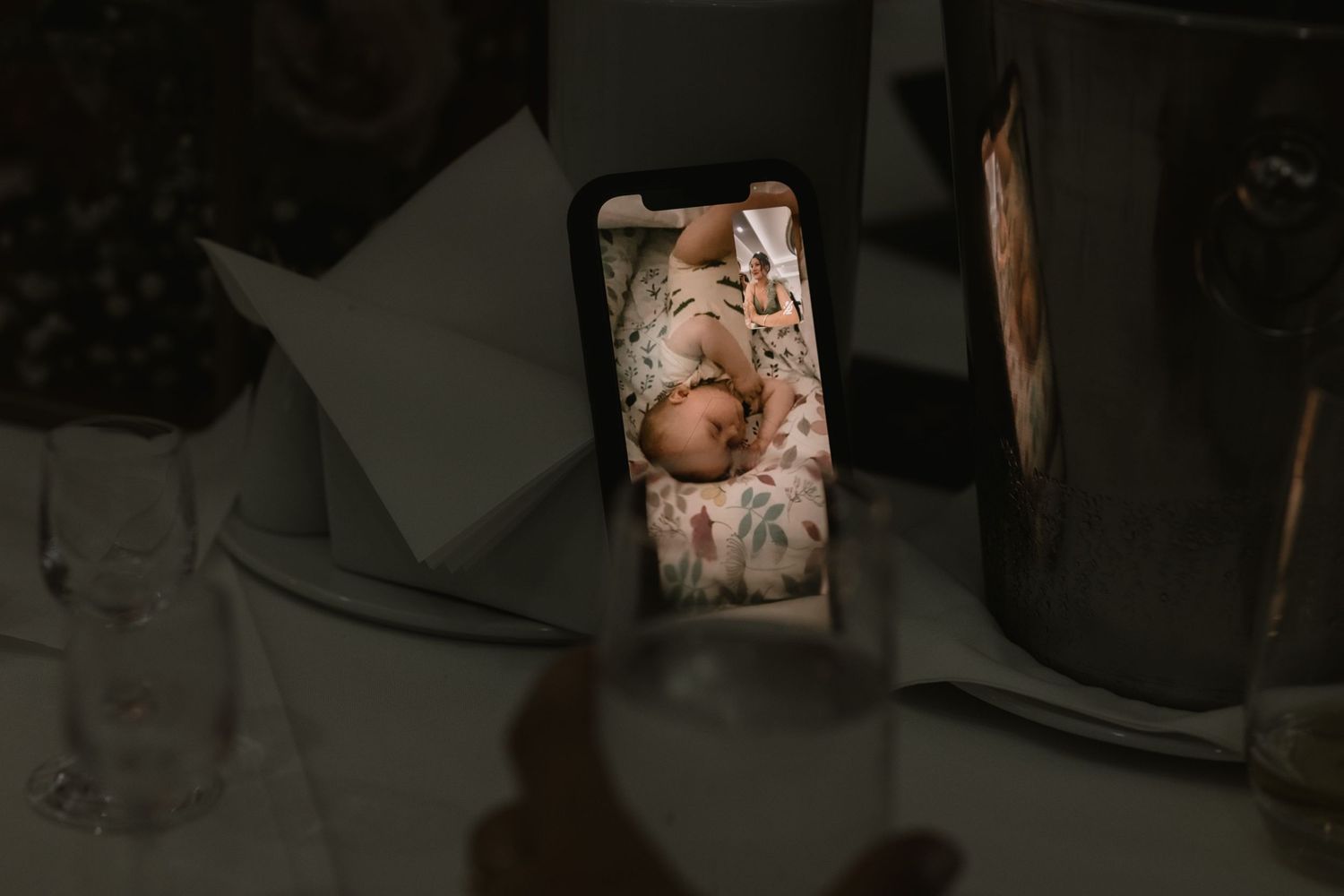 A dimly lit photograph showing a glowing phone screen with an image displayed on it.