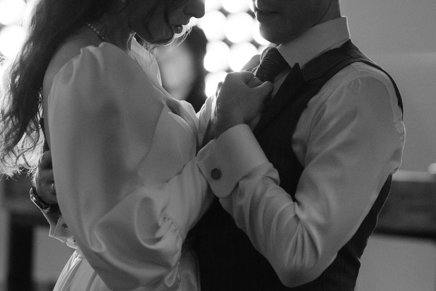 Black and white photo of a couple in formal attire sharing an intimate dance moment together.
