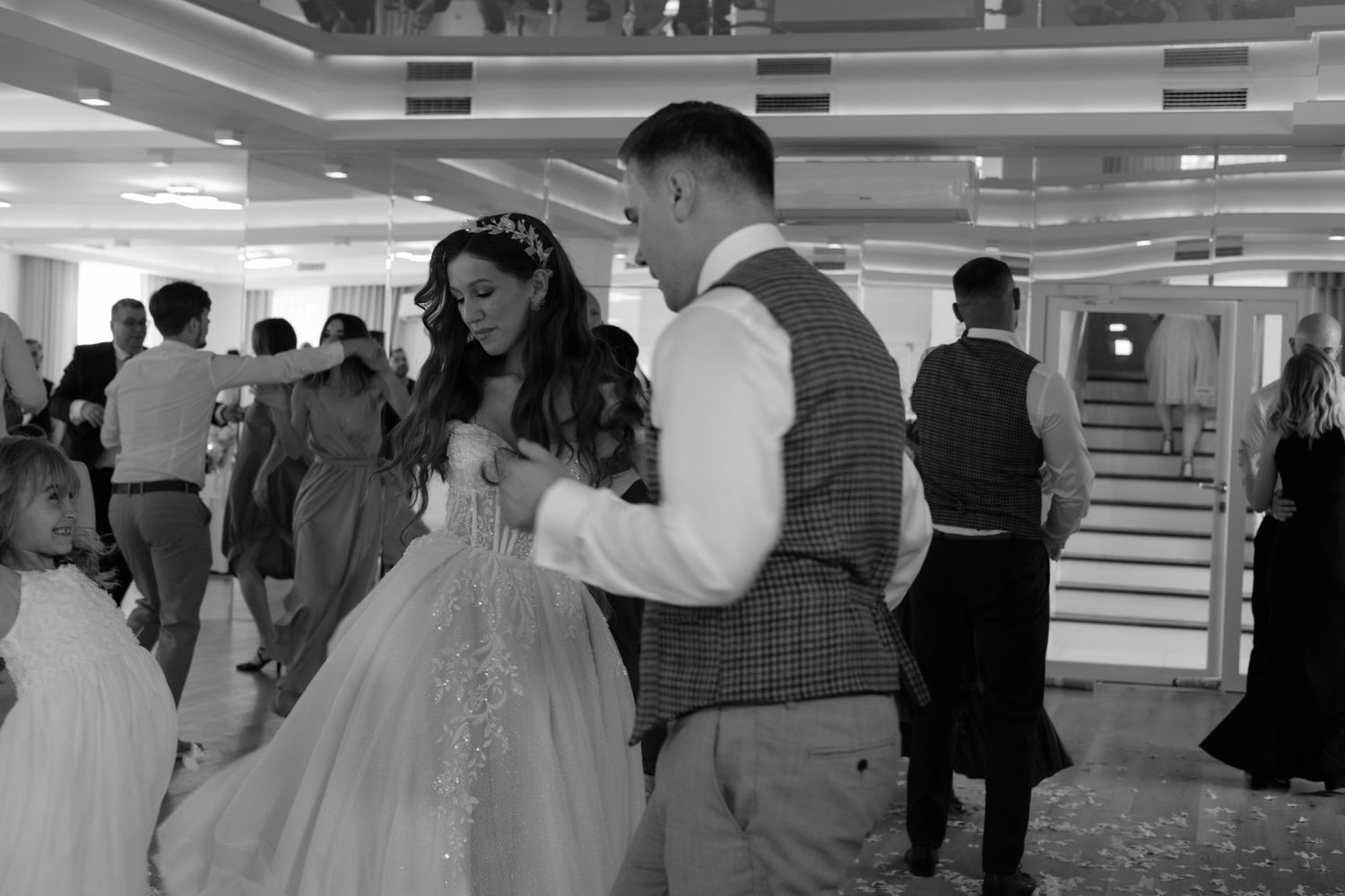 A couple dances together at what appears to be a wedding reception in a ballroom.