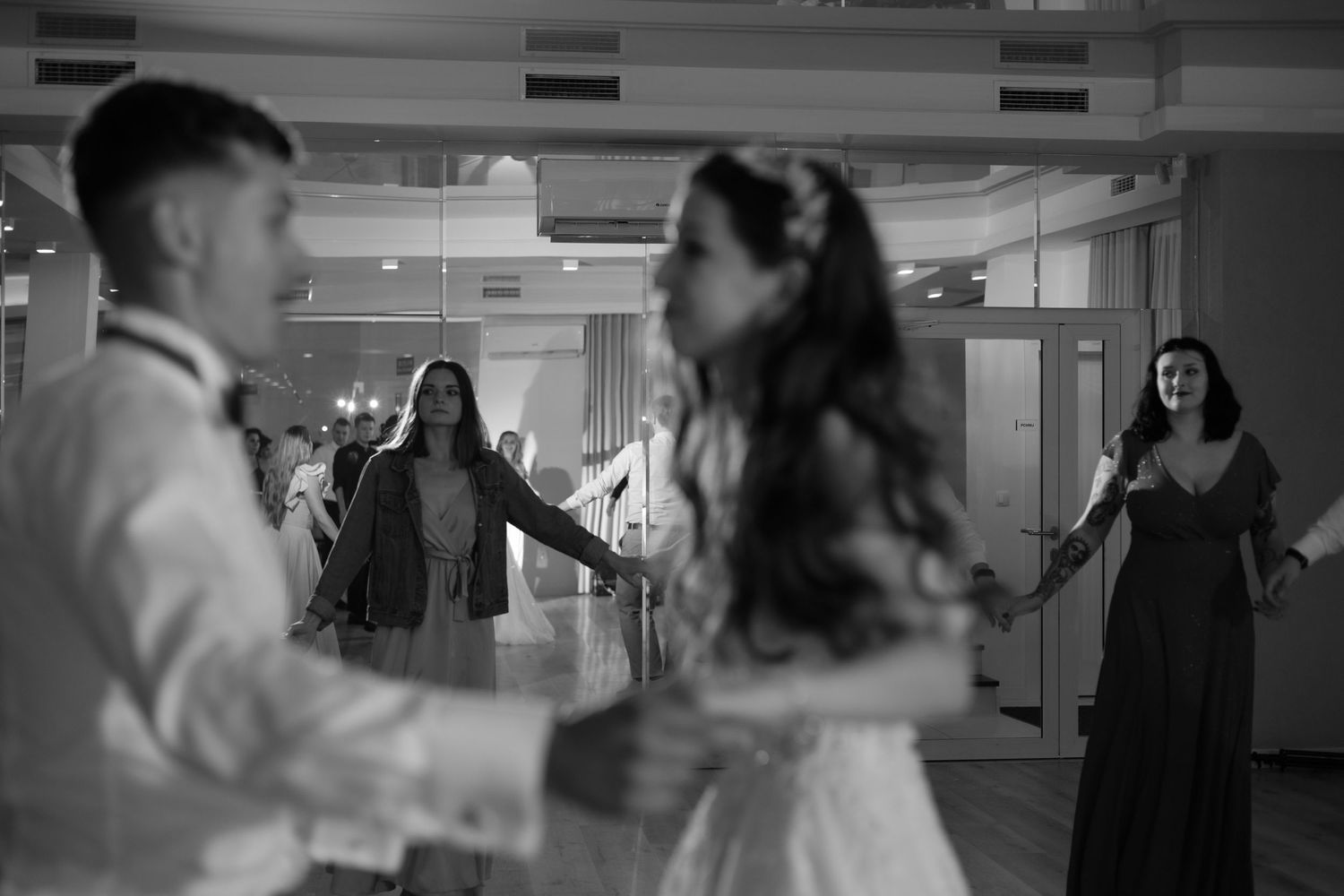 A couple dancing together at their wedding reception in black and white photography.