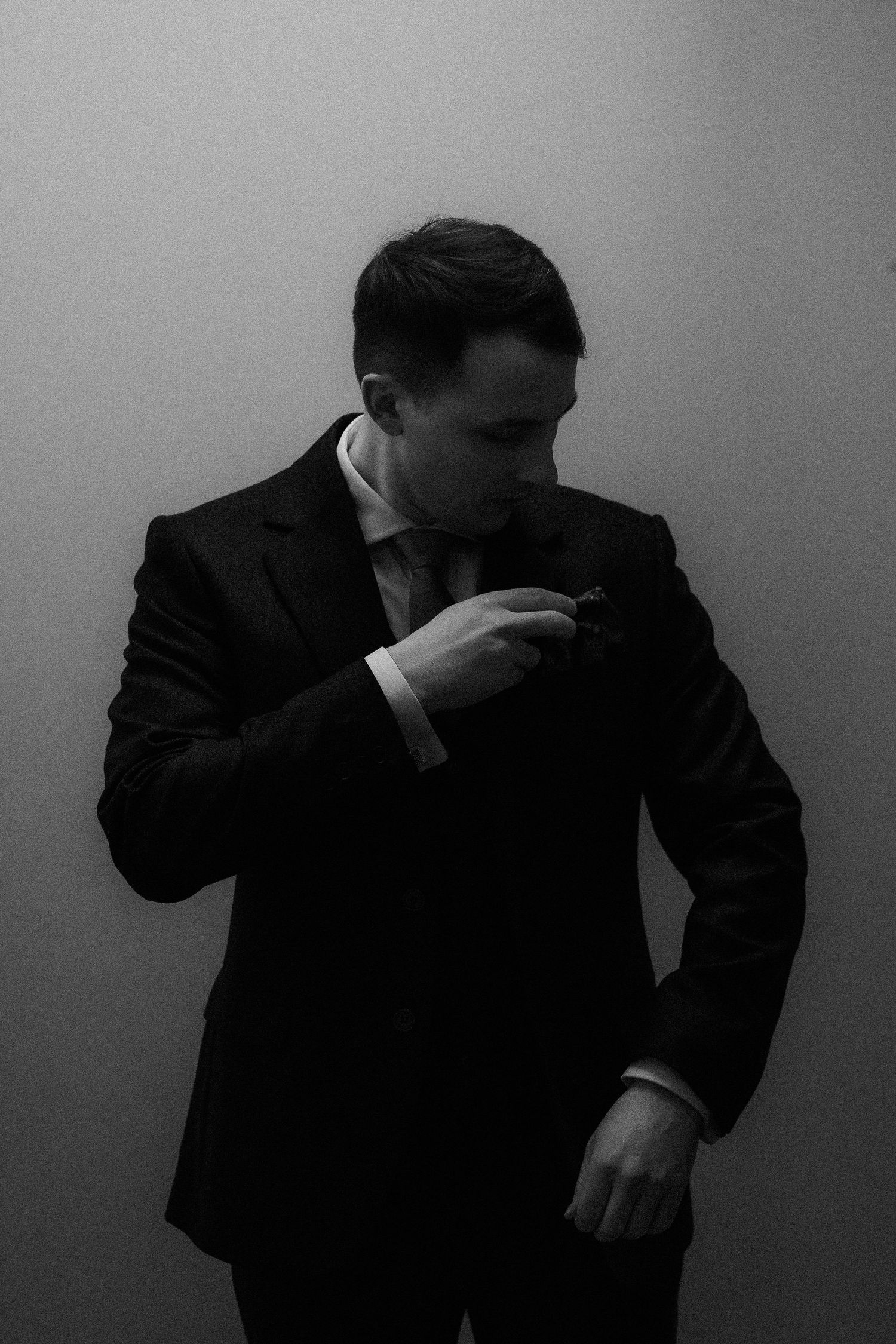 A dramatic black and white sequence shows a person in a suit making expressive movements against a dark background.