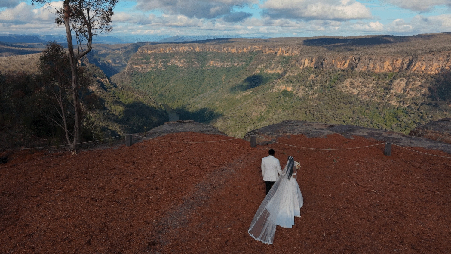 Scenic view of the Blue Mountains National Park in Australia with red soil, eucalyptus trees and dramatic cliff formations.