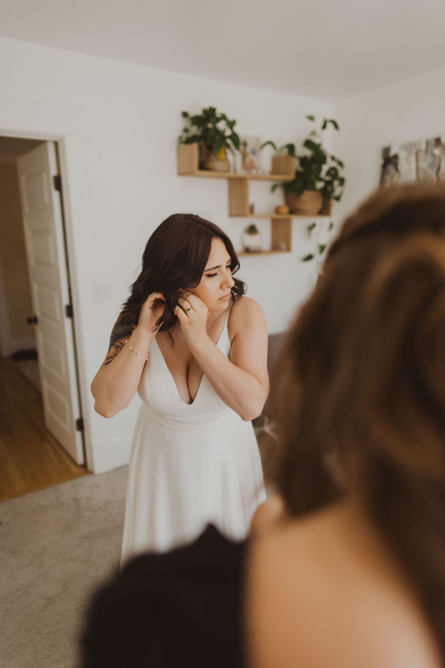 Romantic Seattle bride getting ready for elopement in lush indoor garden at Volunteer Park Conservatory.