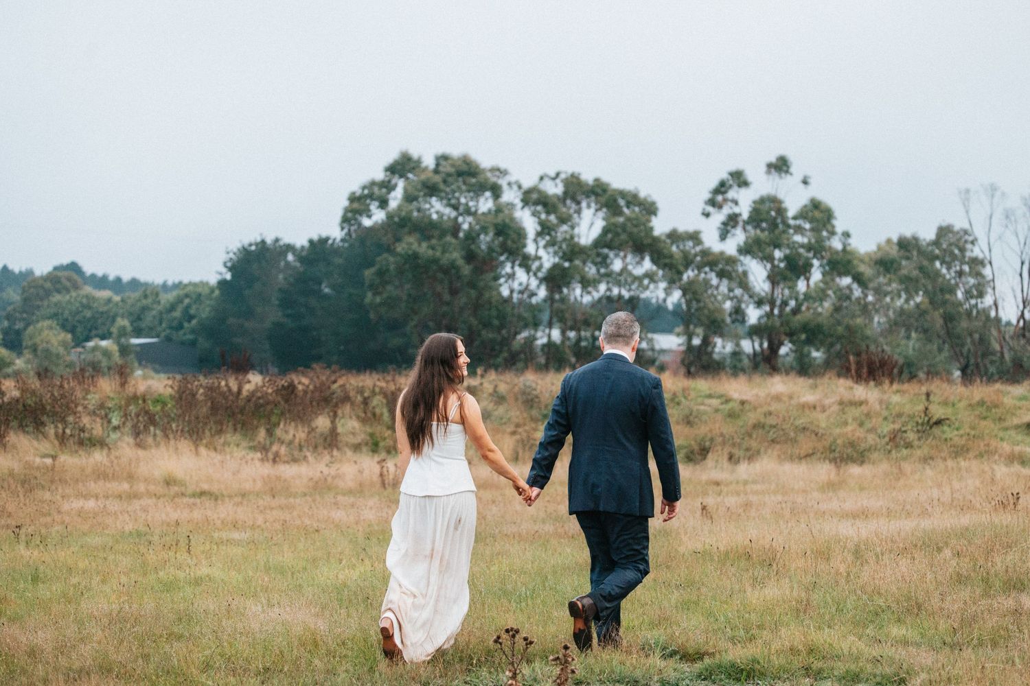 A moment of time captured forever, husband and wife hold hands as they walk into their next chapter