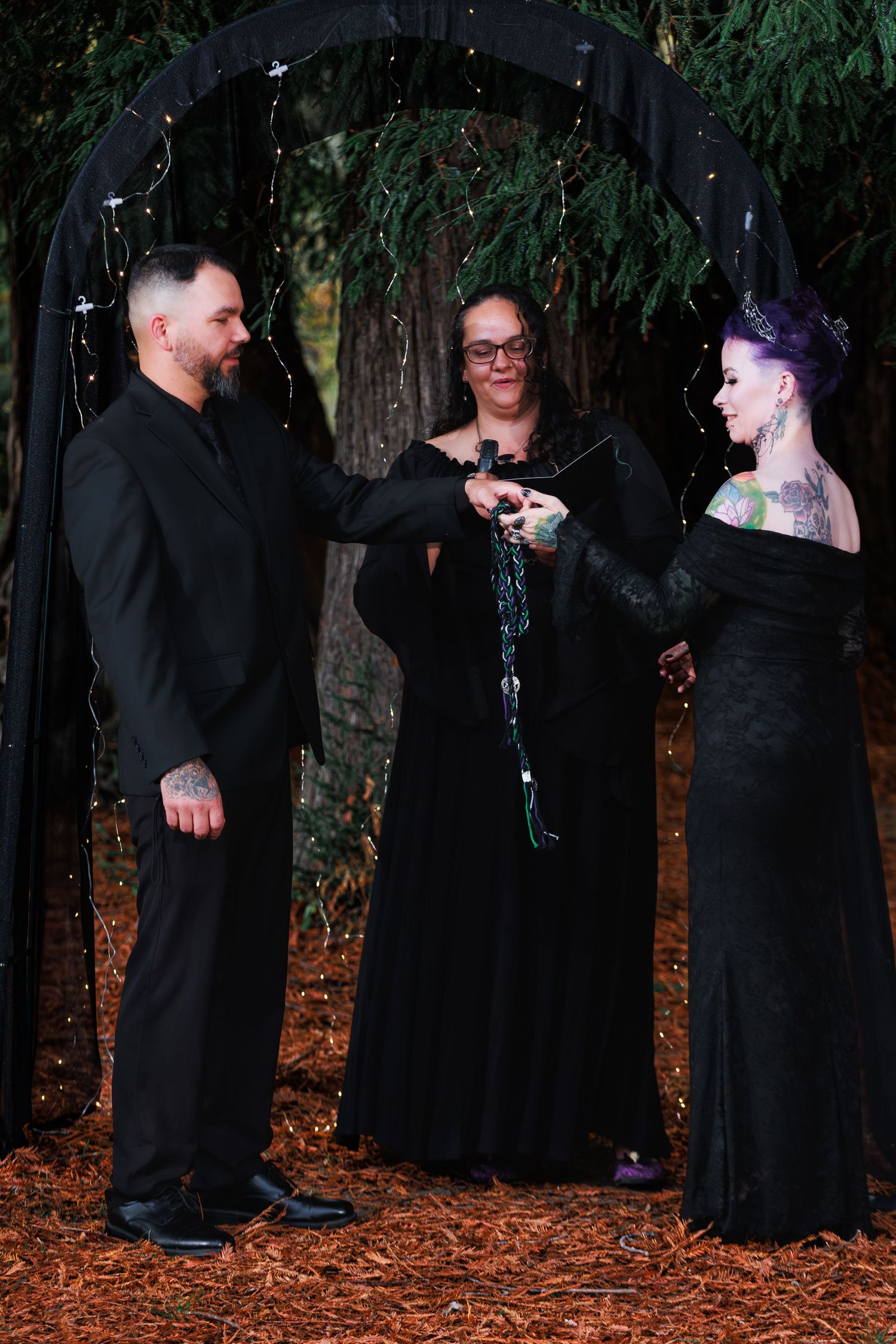 Couple exchanges vows beneath a garden arch during an outdoor vow-renewal ceremony.
