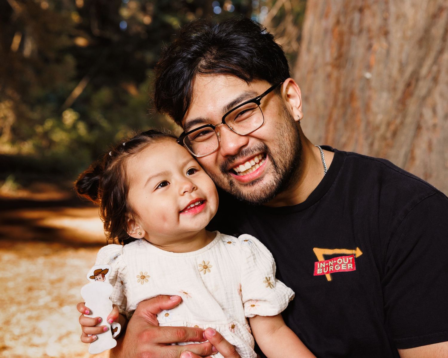 Father smiling with young child during outdoor family photo session