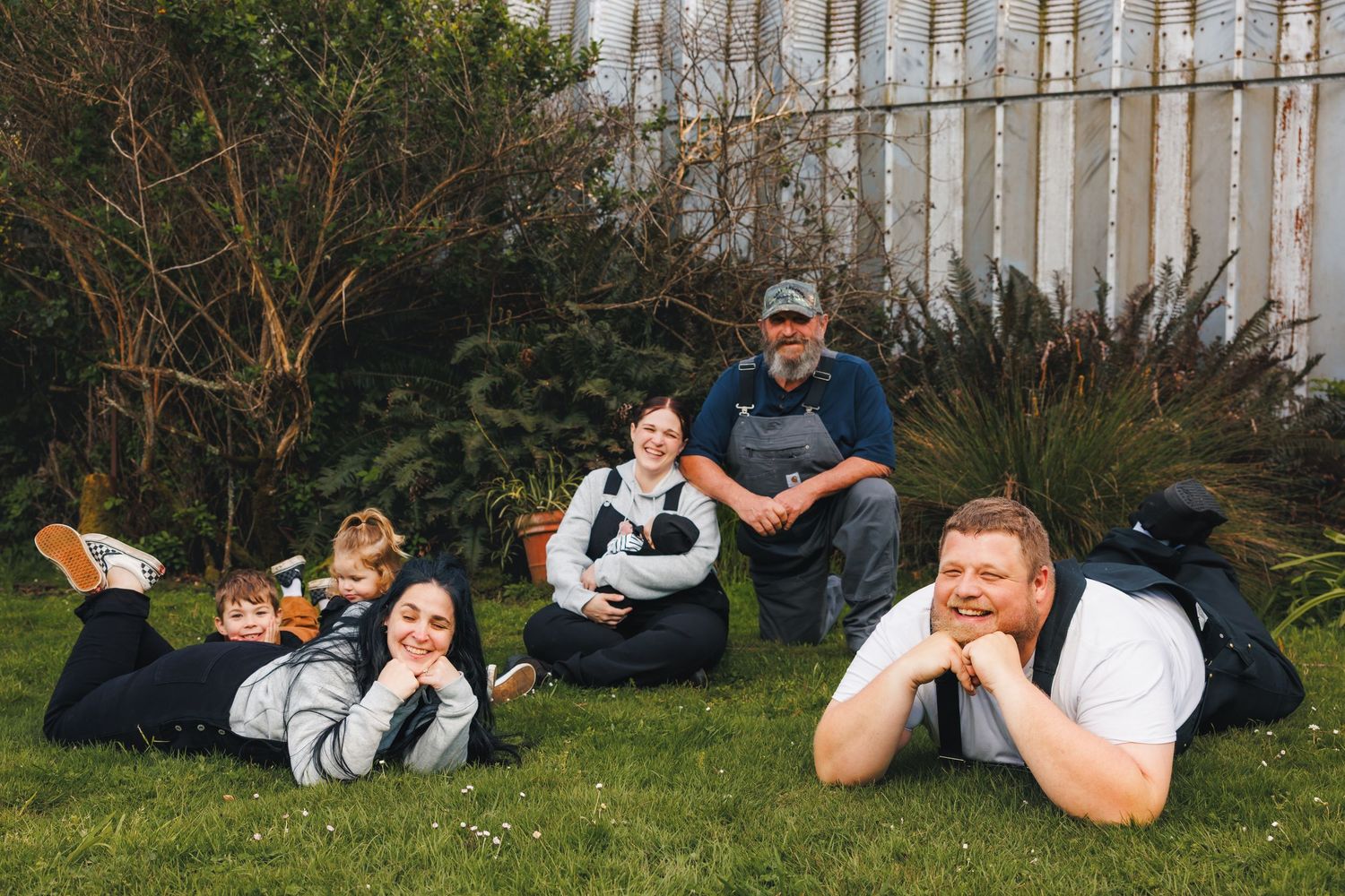 Family relaxing together on grass during outdoor family session