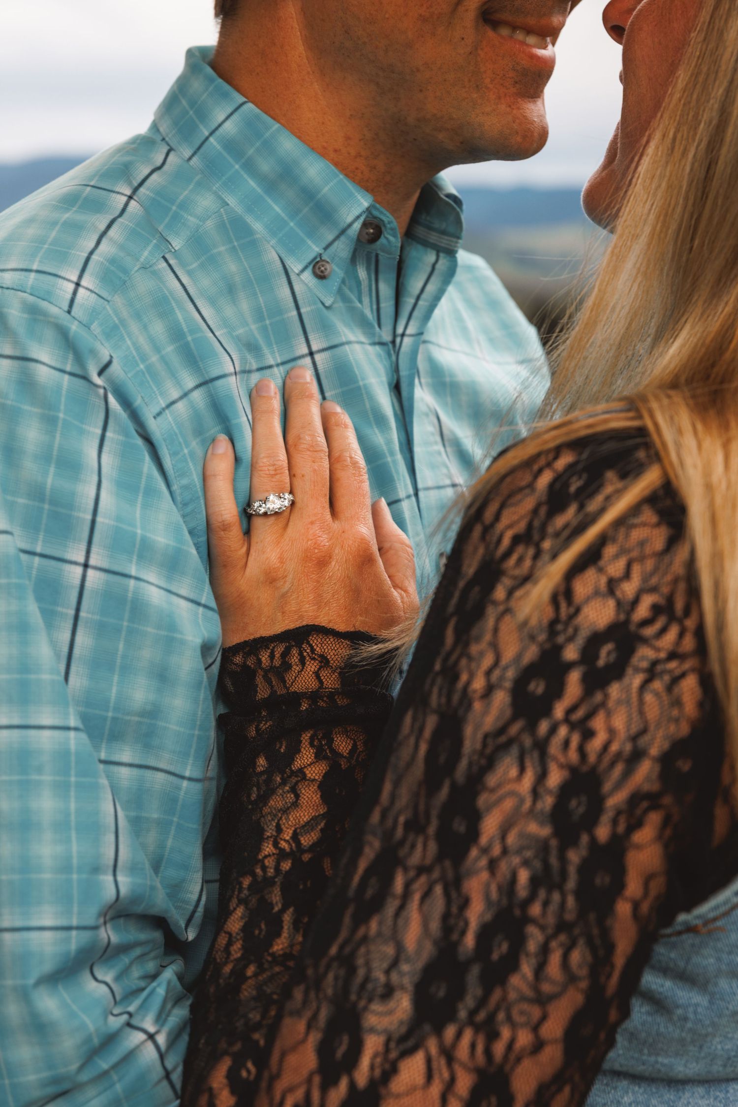 Close-up of a woman’s hand resting on her partner’s chest during a couples portrait.