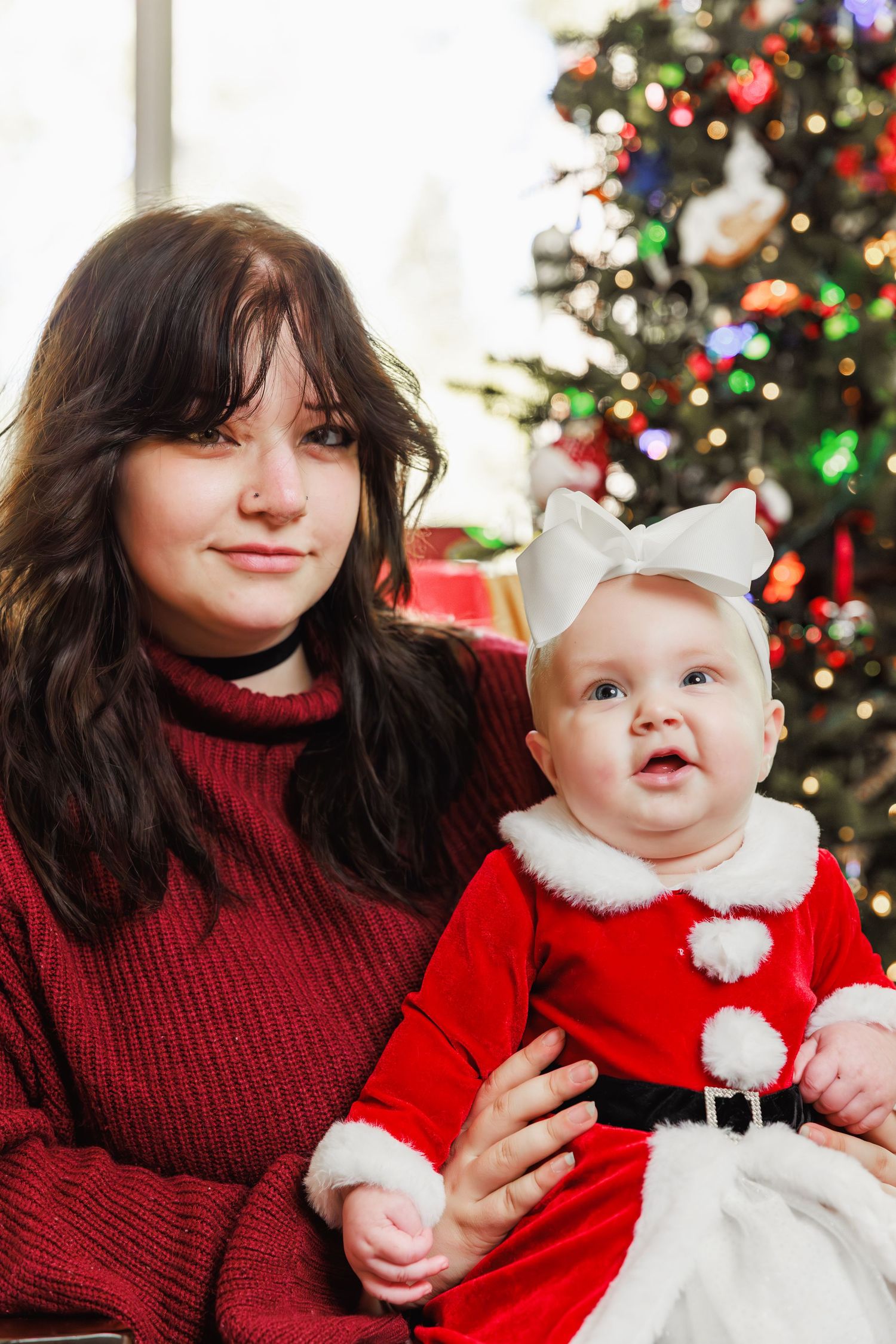 Mother holding baby in red outfit during holiday family session