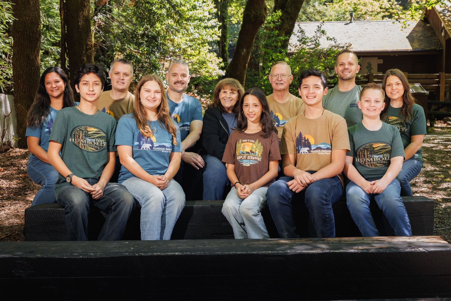 Extended family gathered together among towering redwood trees during a family photography session in Humboldt County, California.