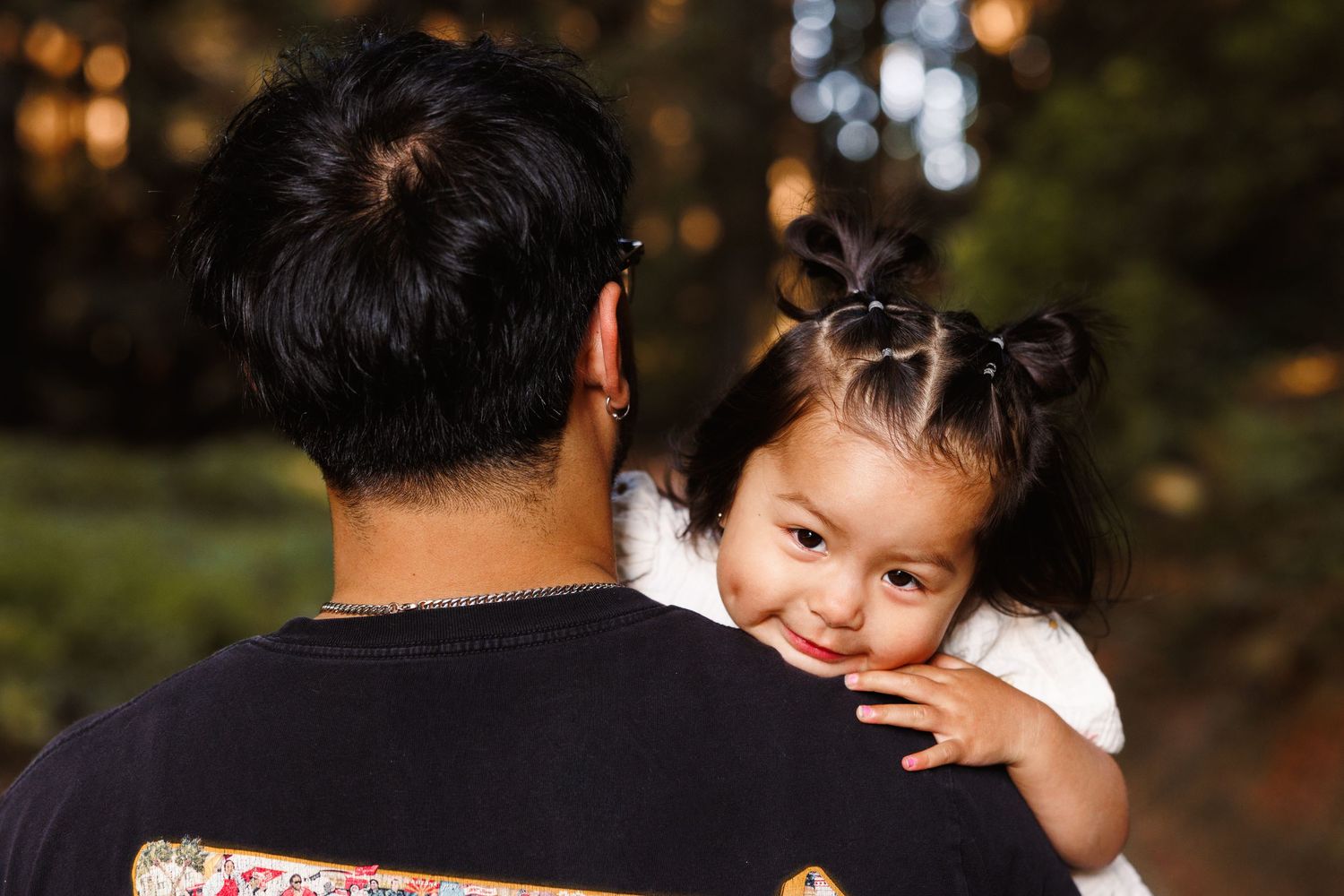 Father holding young child during warm outdoor family session