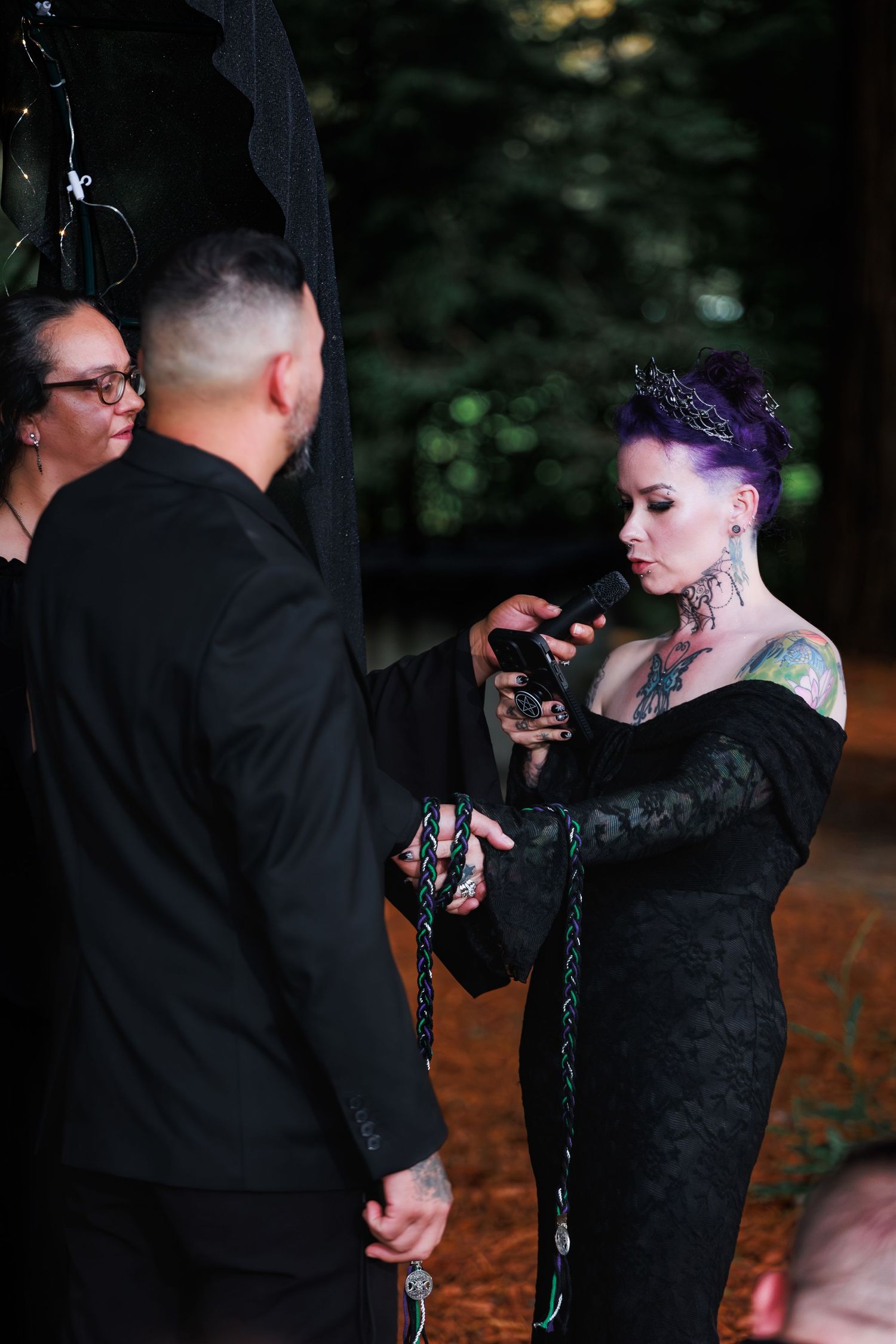 Couple holds hands during an intimate outdoor vow-renewal ceremony.