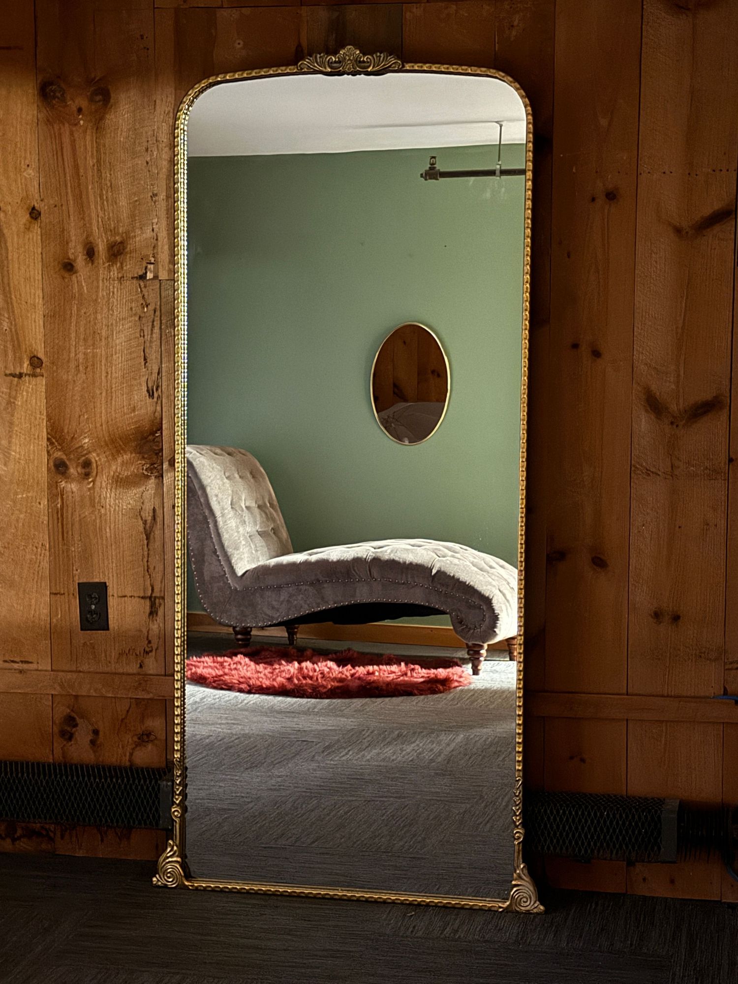 Full length mirror reflecting the bad and sage green walls of the Sweet Room at Sacketts Brook Boudoir in Putney, Vermont.