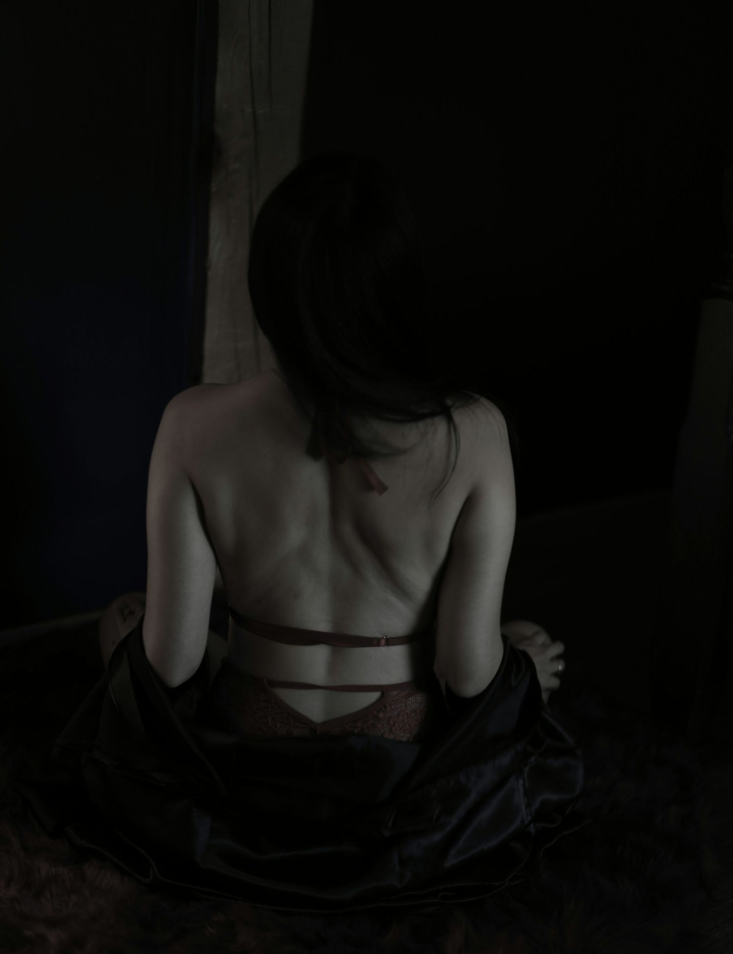 Woman posed against a dark background in lingerie, during a fine-art boudoir session in Putney, Vermont.