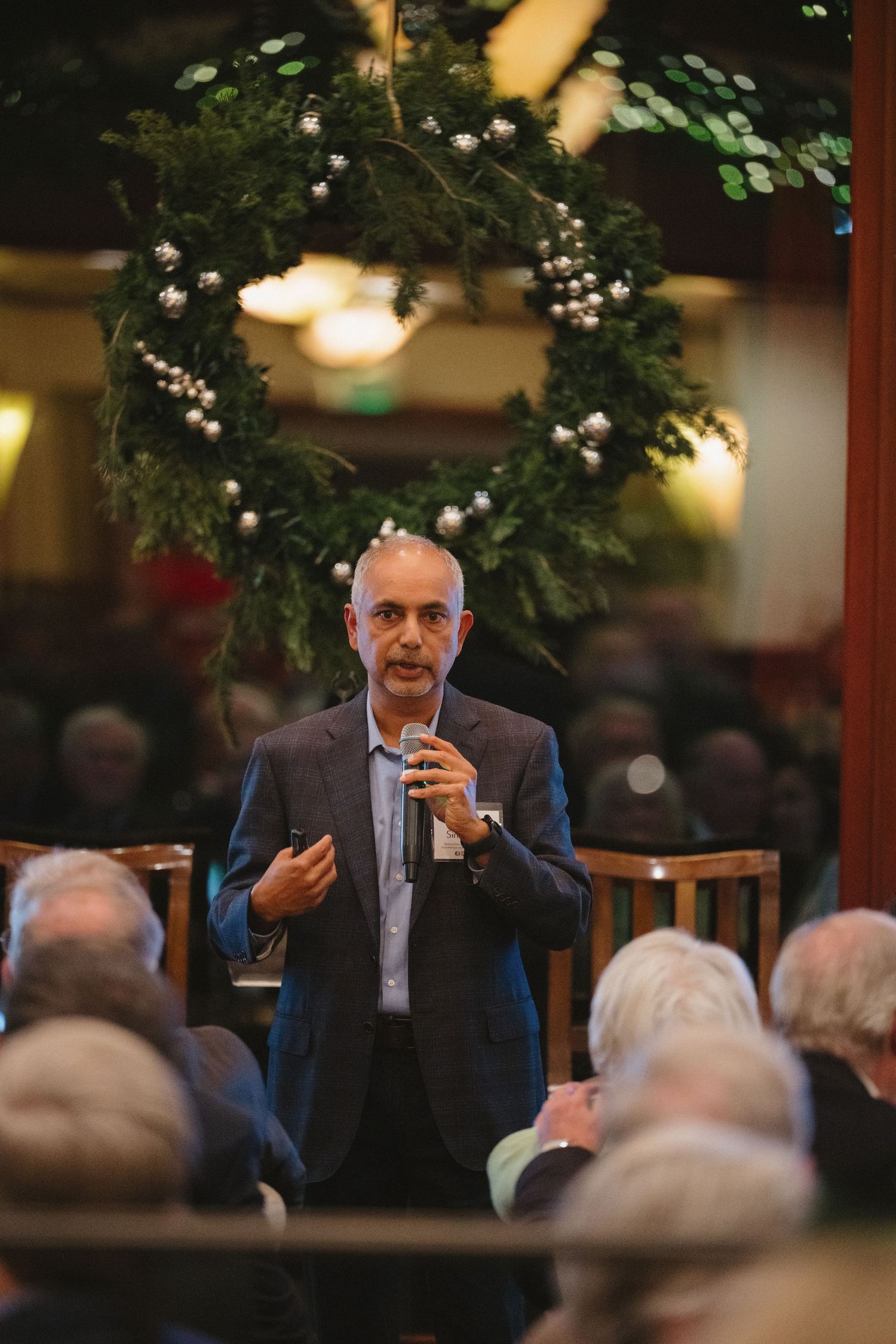Event storytelling photography documenting a speaker addressing guests during a nonprofit donor celebration.