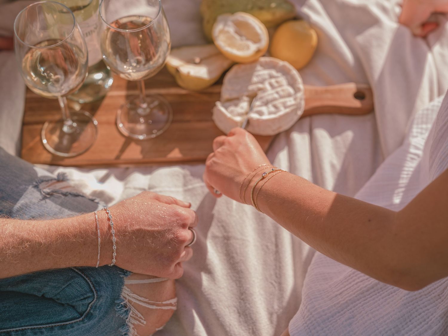 Lifestyle brand photography capturing a relaxed outdoor gathering with food, drinks, and natural connection.