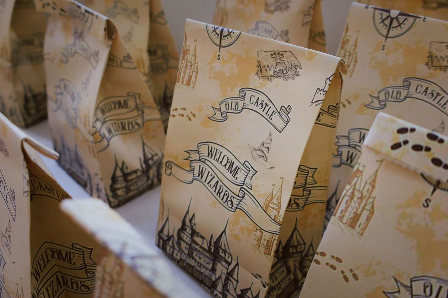 Harry Potter themed party favor bags with wizard castle designs arranged on a table.