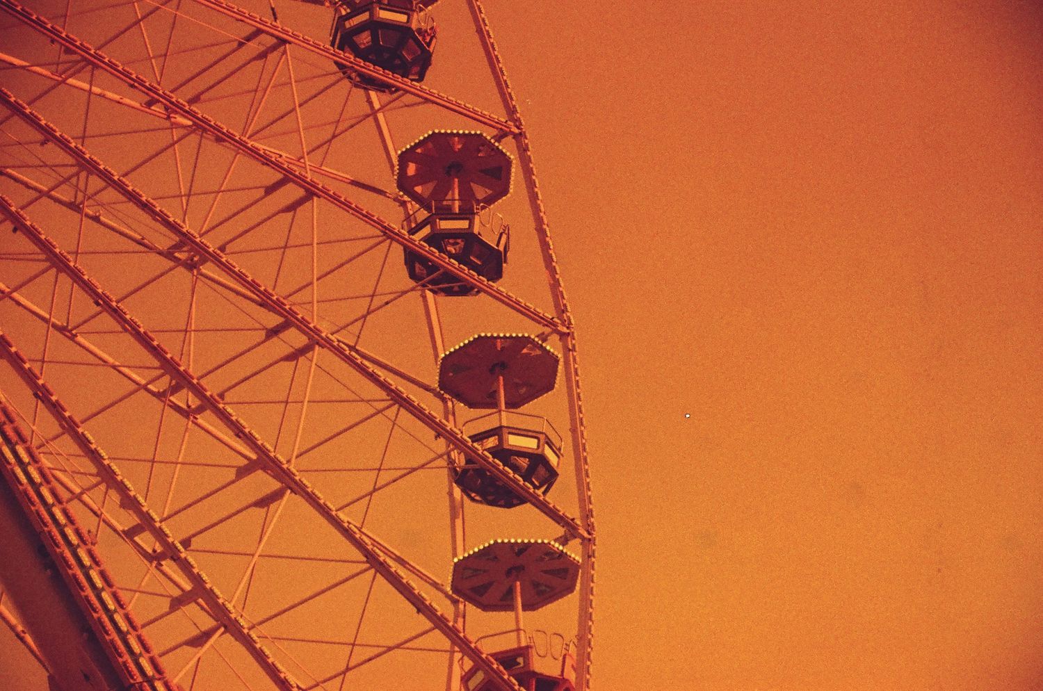 A colored close-up 35mm film of the ferris wheel at the funfair